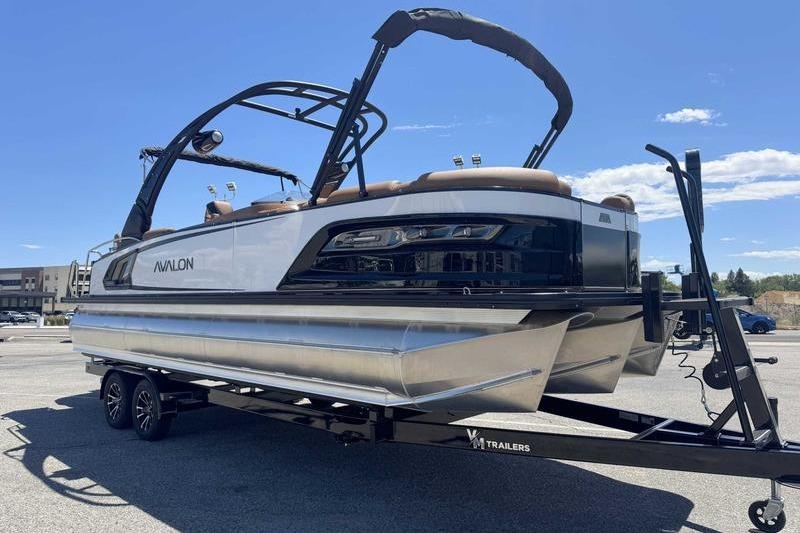 2026 Avalon Excalibur LTD Quad Lounge pontoon boat on trailer, sunny day.