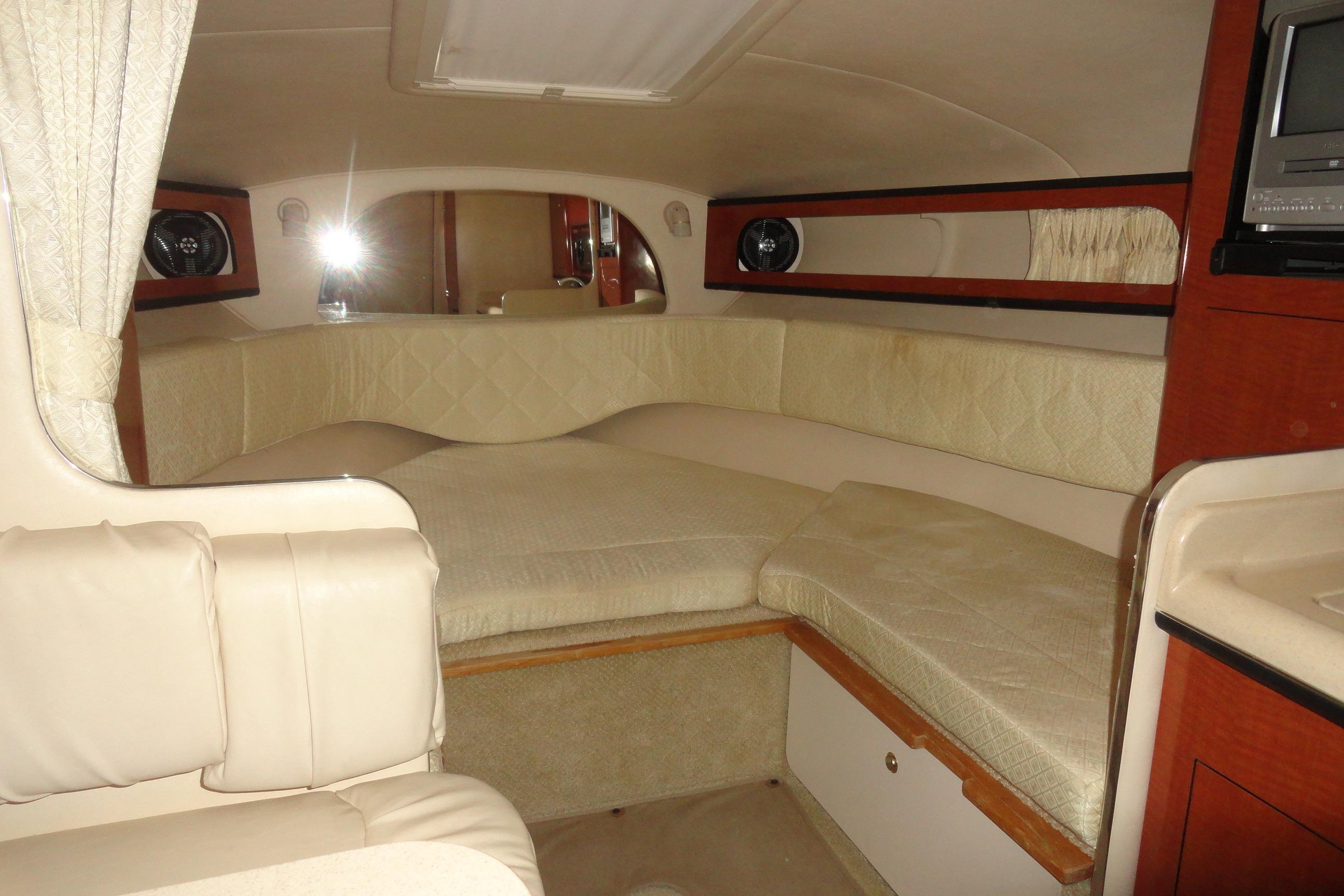 2004 Sea Ray Sundancer 280 cabin interior with beige seating and wood accents.
