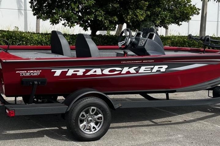 2025 Tracker Pro Team 195 Tournament Edition boat, red with sleek design, parked outdoors.