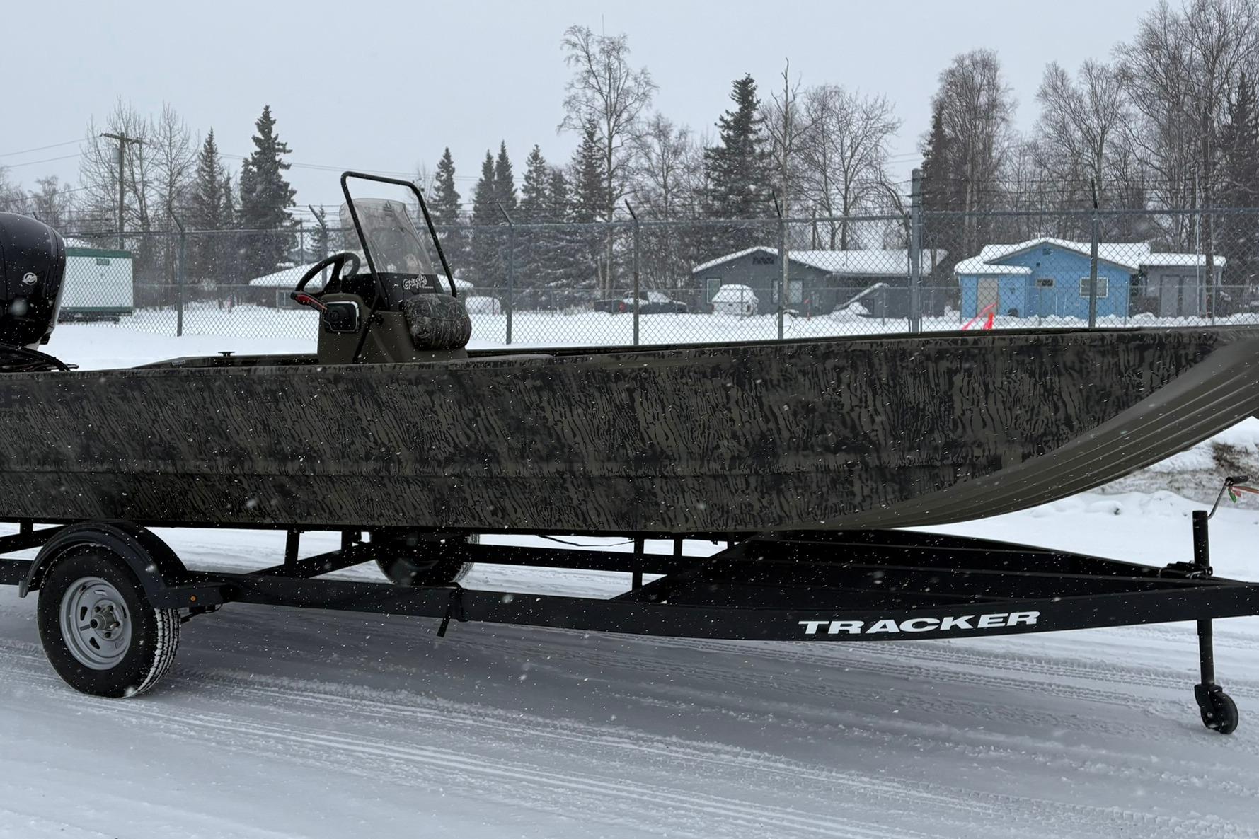2025 Tracker Grizzly 2072 CC boat on trailer in snowy landscape.