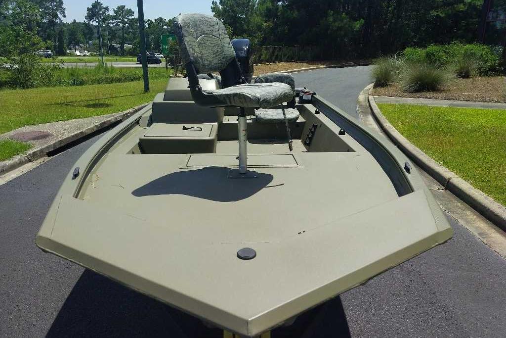 2026 Tracker Grizzly 1754 SC boat with camo seating, parked on a paved road.