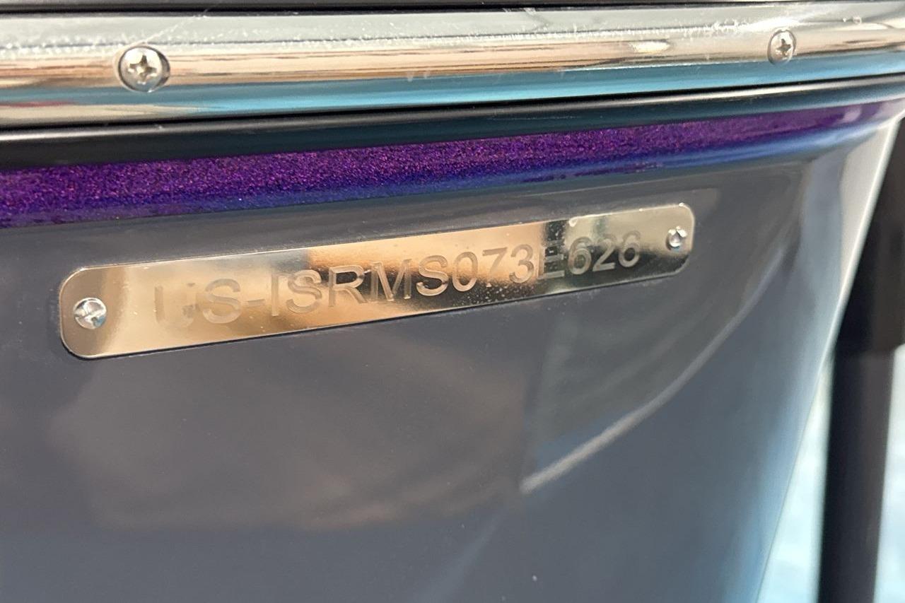 Close-up of a boat hull with a metal plaque displaying a serial number.