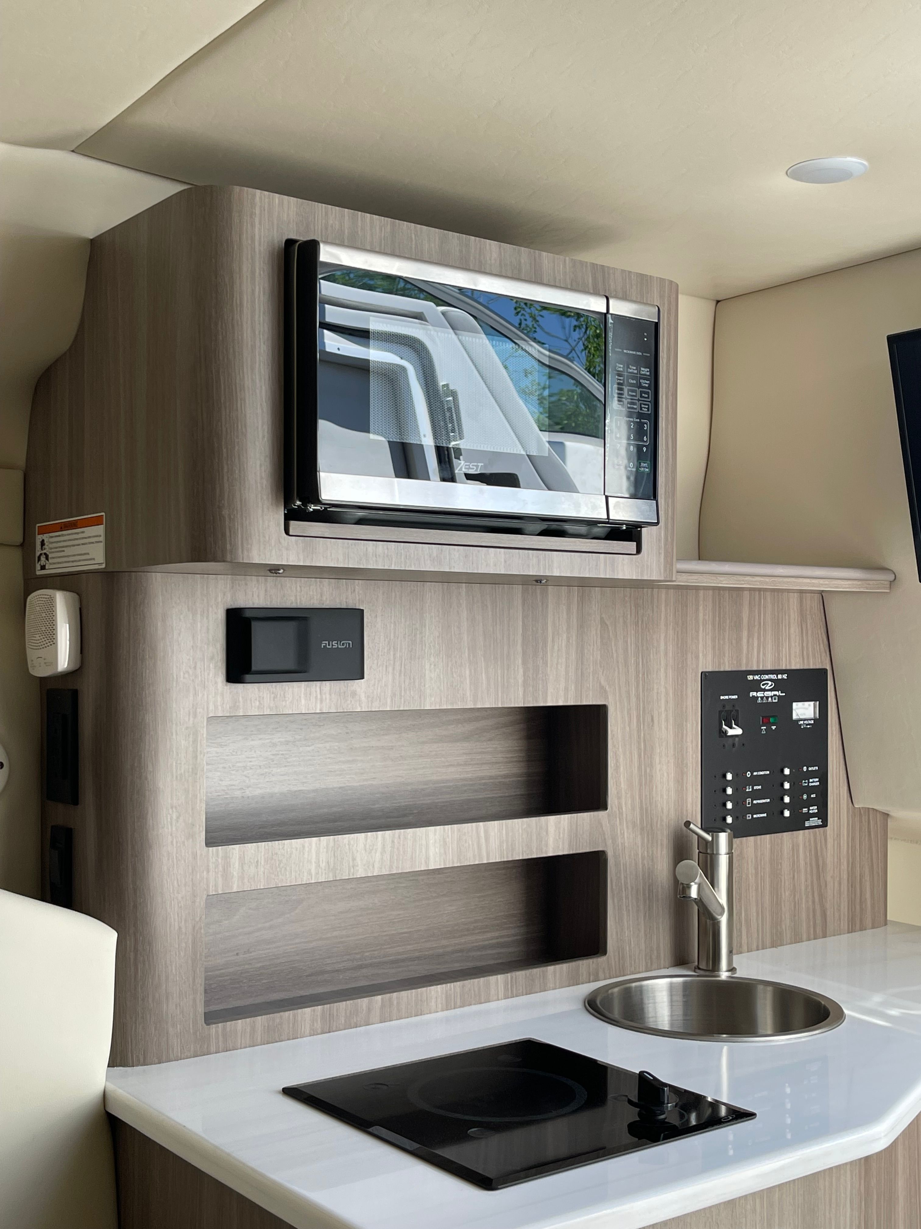 Interior of 2022 Regal 26 Express with kitchen and microwave.