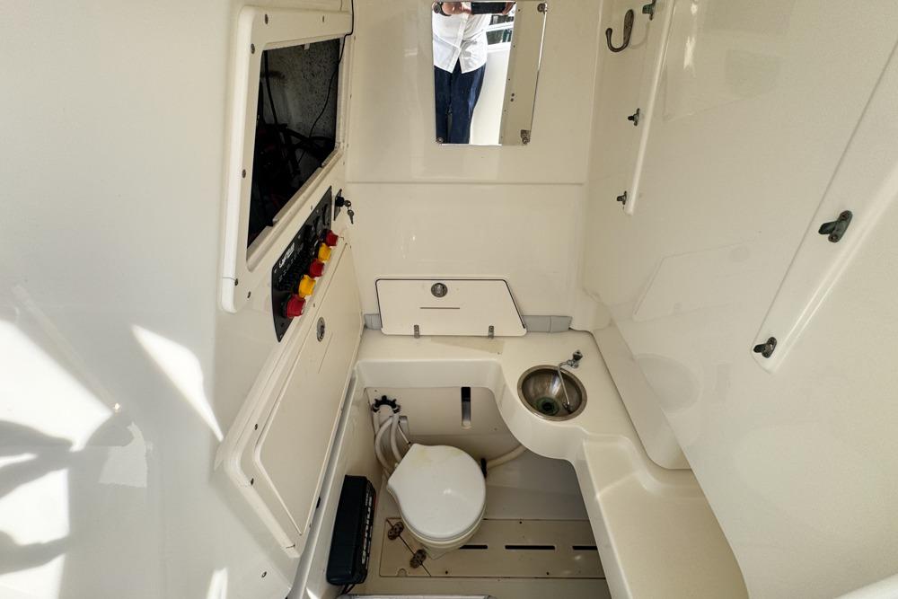 2018 Mako 284 Center Console boat interior with sink and toilet.