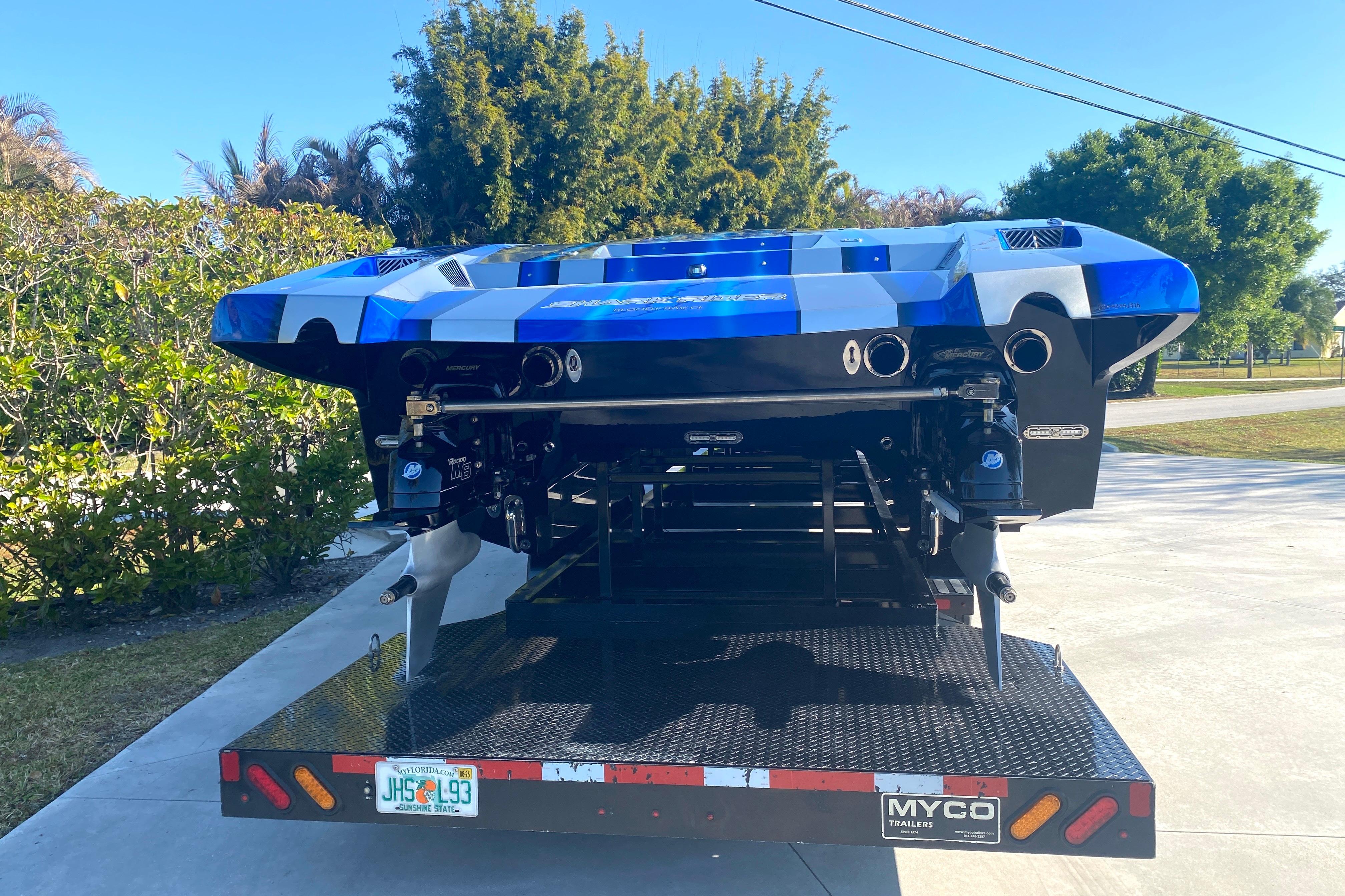 2016 MTI 44 RP powerboat on trailer, featuring sleek blue and white design.