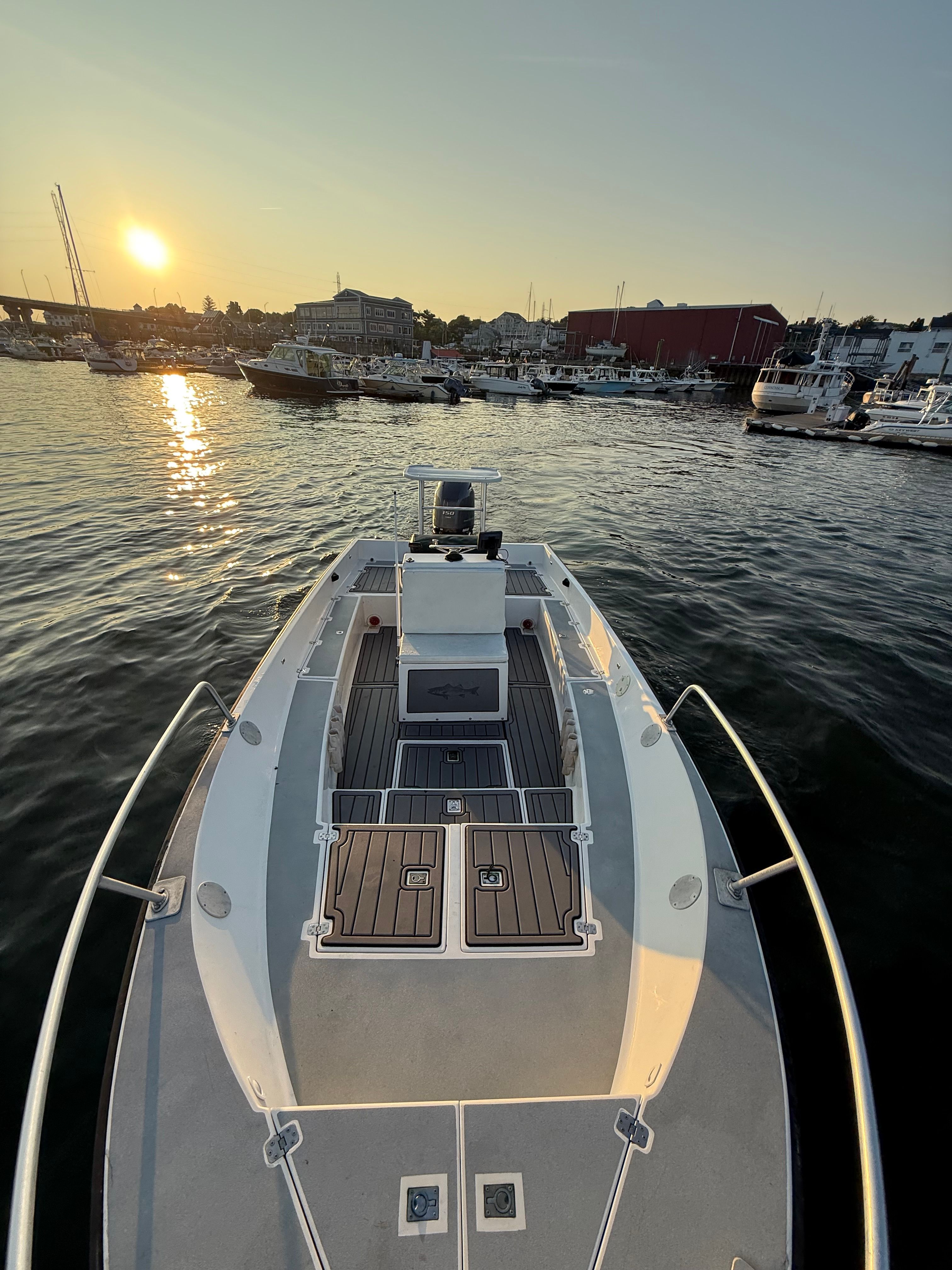Custom Sea Fly 2004 boat at sunset in a marina, surrounded by other vessels.