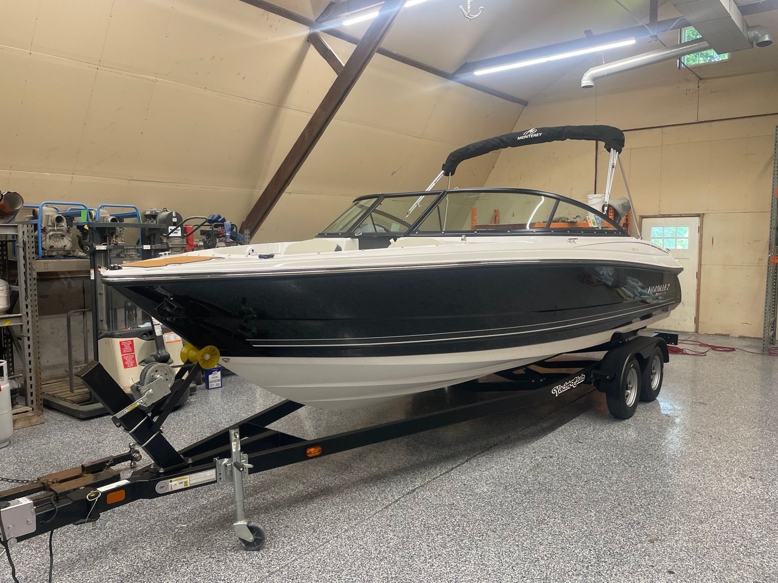 A 2023 Monterey 224FS boat on a trailer inside a garage.