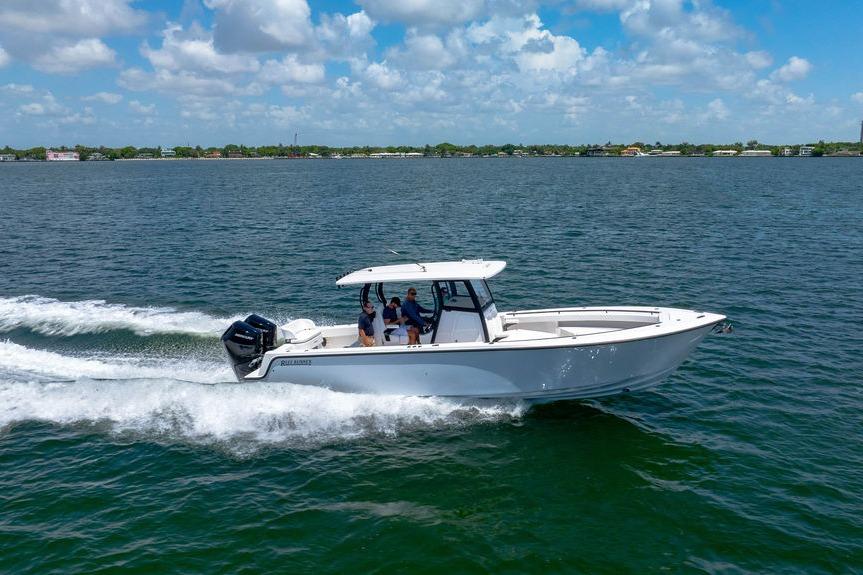 2027 Reef Runner 340 boat cruising on open water under a clear blue sky.