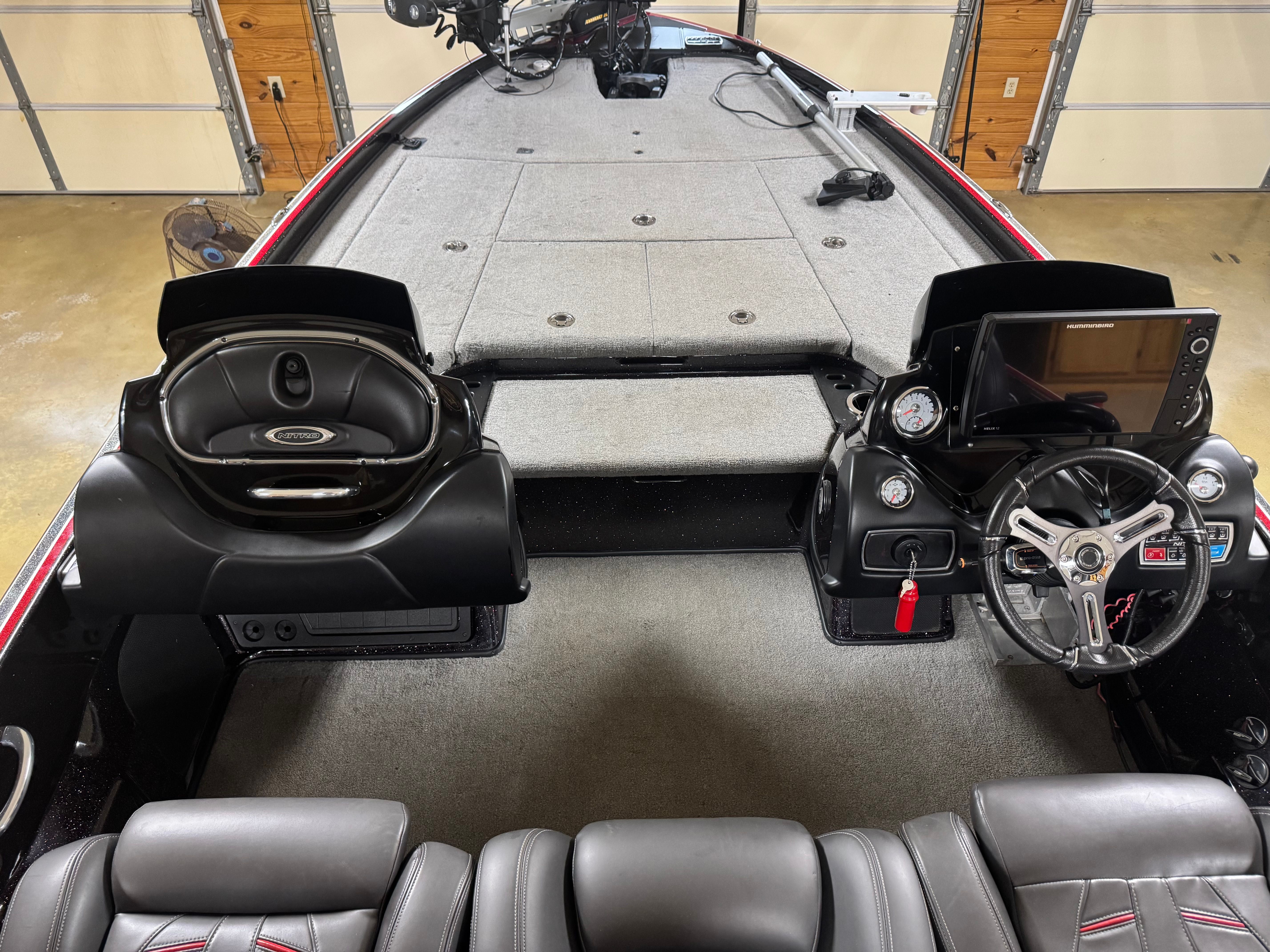 The image shows the cockpit of a Nitro Z21 boat with gray carpeting.
