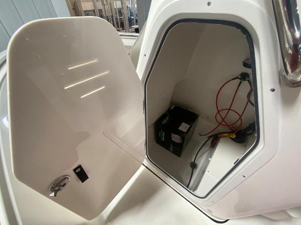 2024 Key West 189 FS boat storage compartment with battery and wiring.