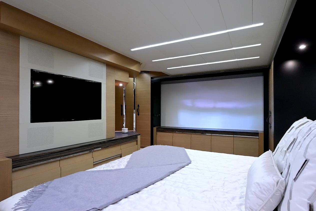 Luxurious bedroom interior on 2015 Pershing 92 yacht with modern TV and sleek design.