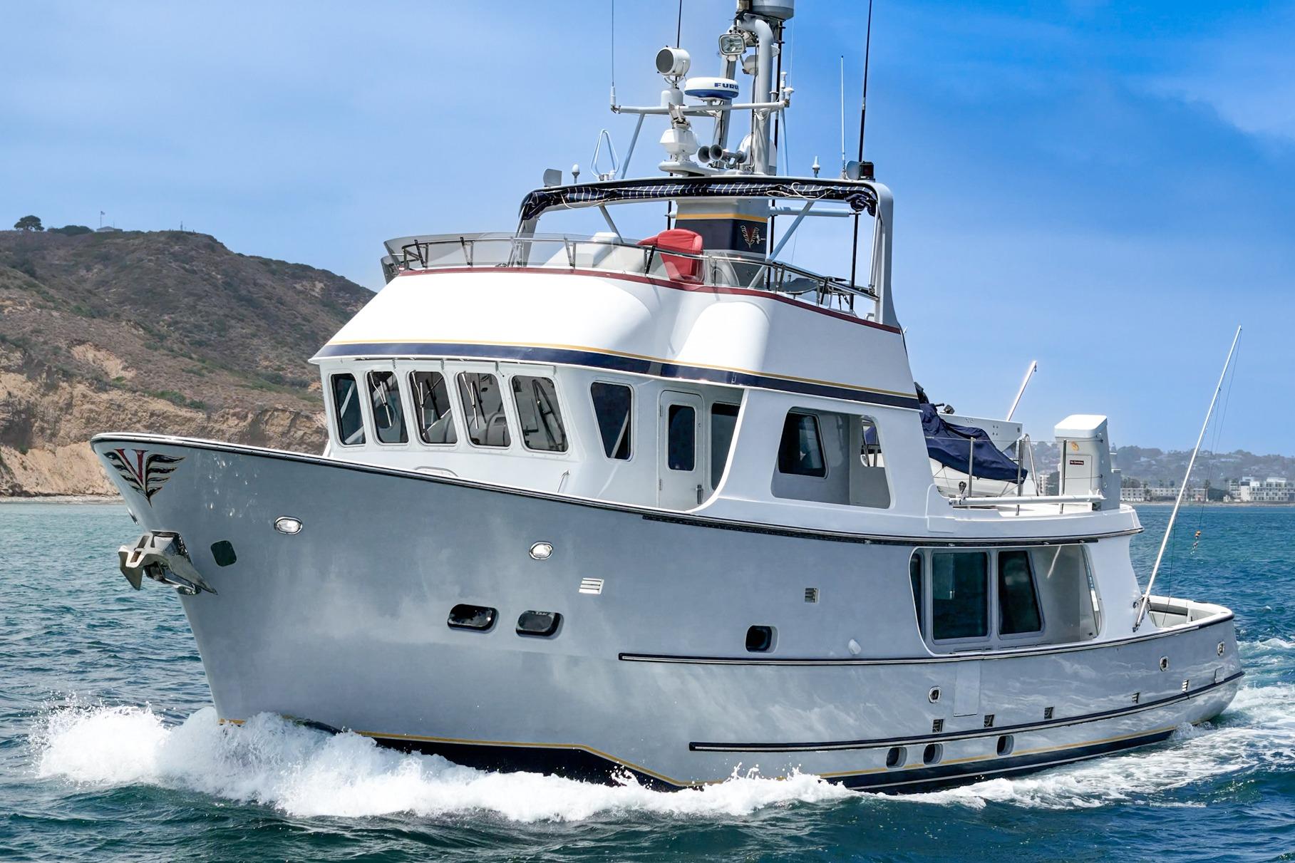 1990 Seaton Long Range Cruiser yacht navigating coastal waters under clear blue skies.