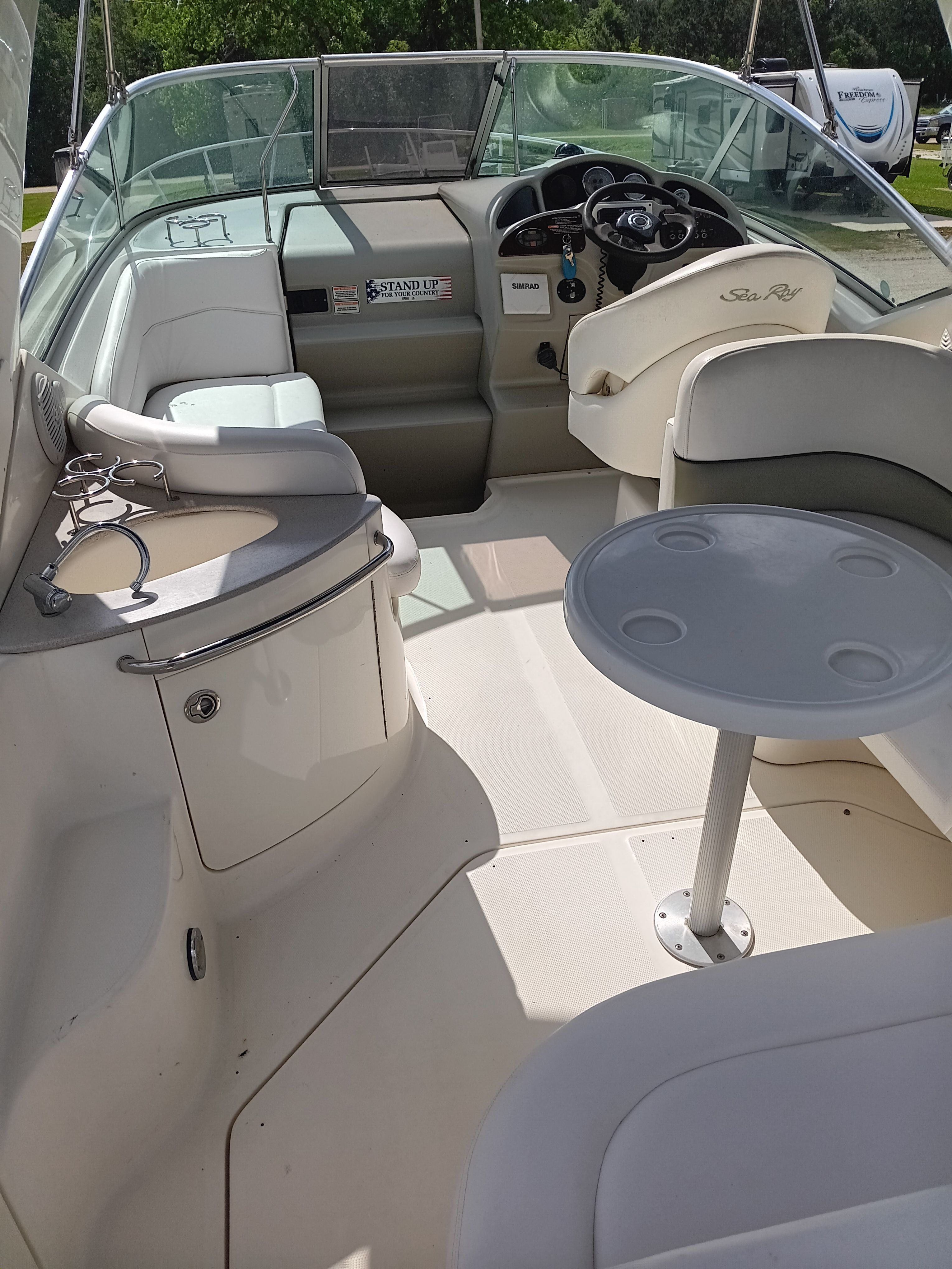 The image shows the cockpit of a 2005 Sea Ray 260 DA Sundancer with a helm and table.