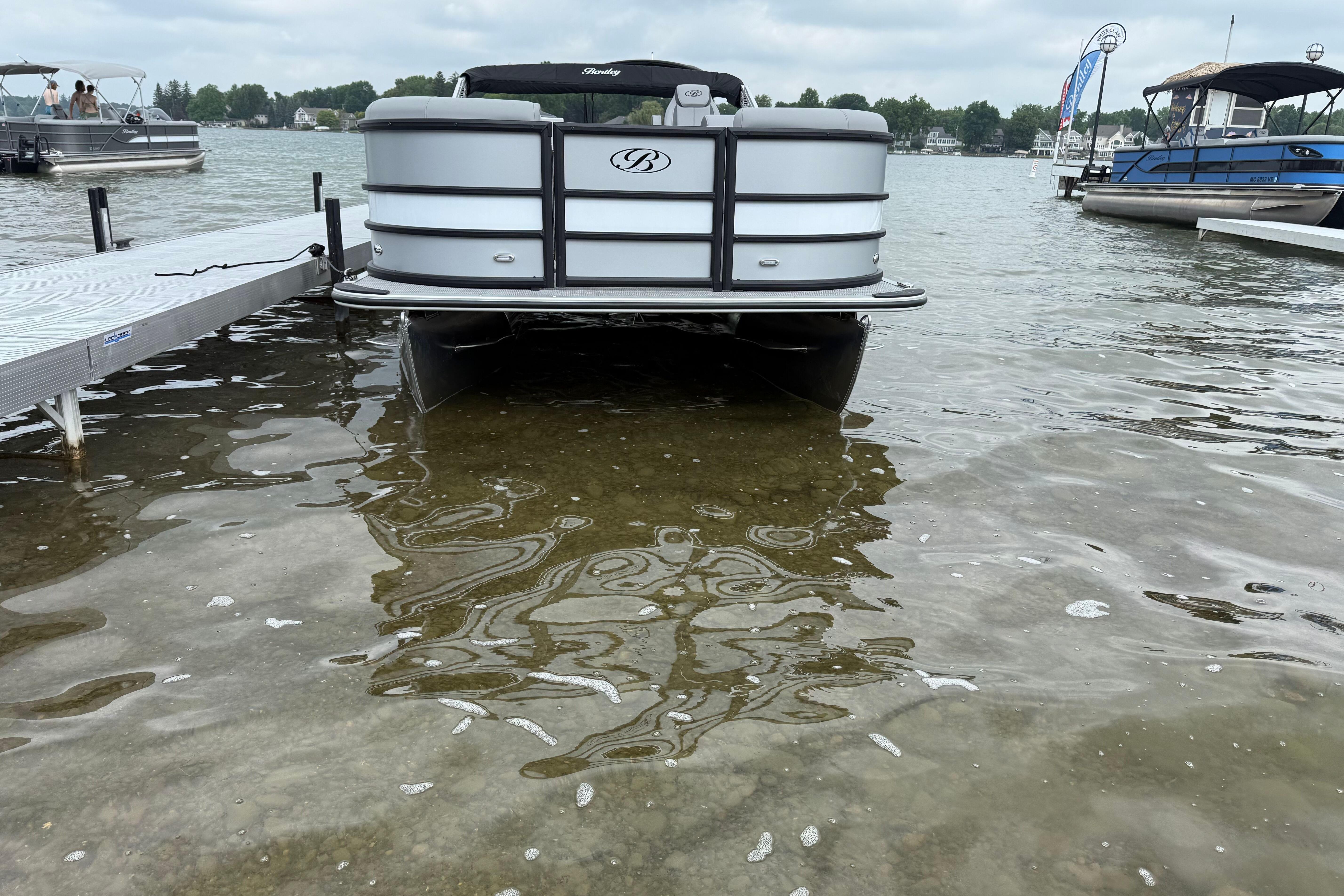 2026 Bentley Pontoons Legacy 220 Navigator docked on a calm lake.