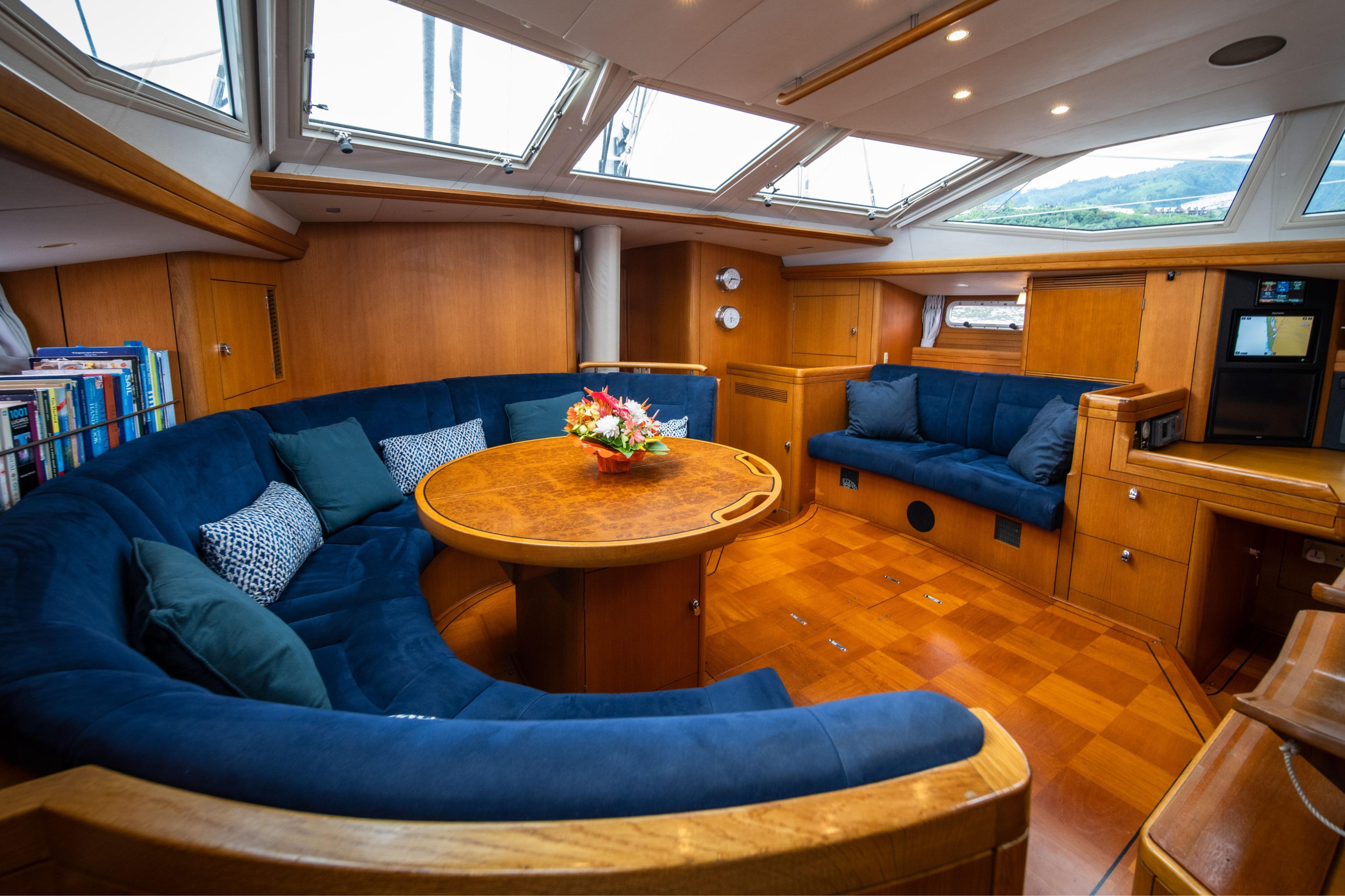 Luxurious interior of a 2004 Oyster 56 yacht with plush seating and wooden finishes.