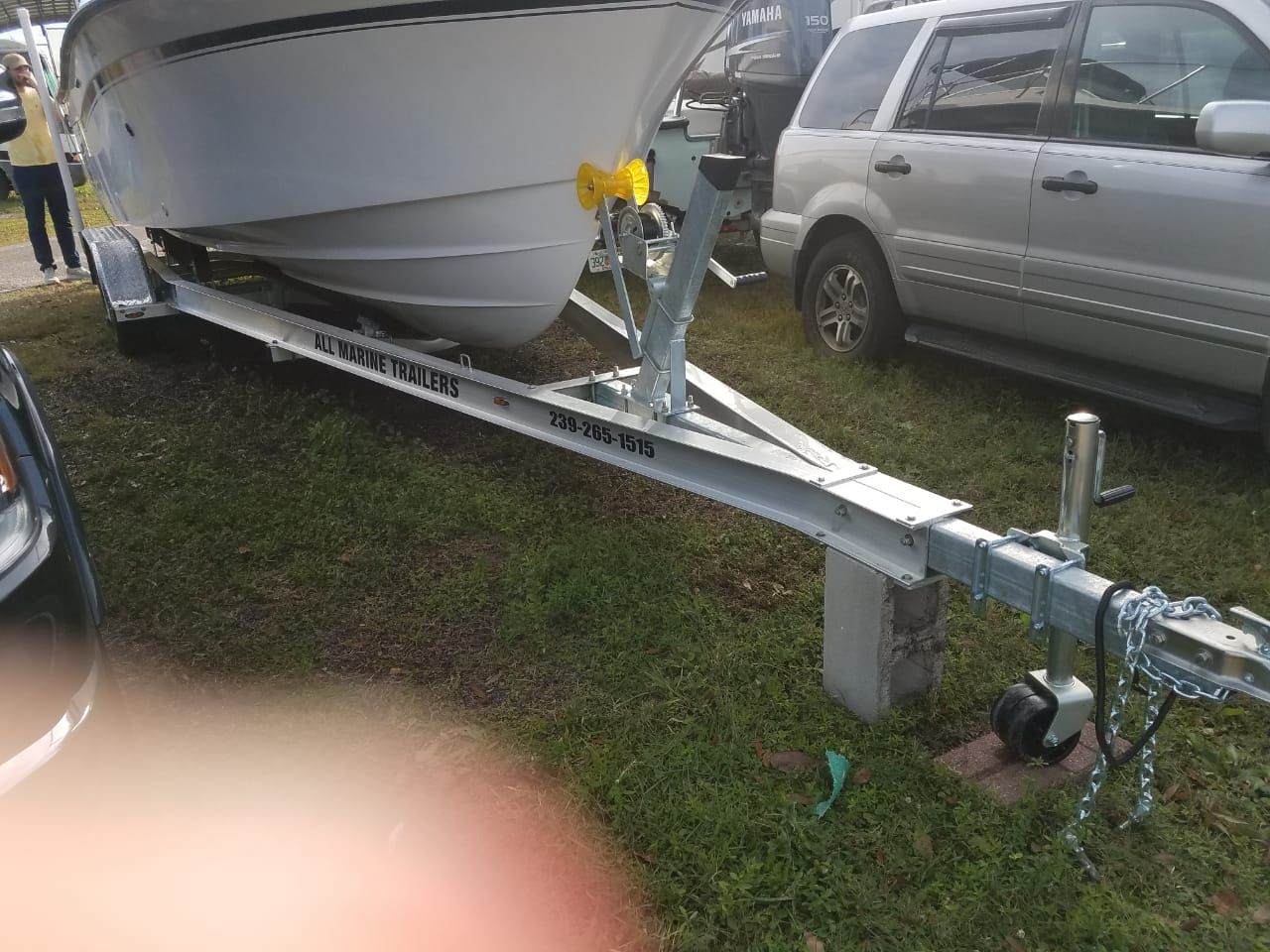 A 1995 Grady-White Explorer 24 boat is on a trailer on a grassy area.