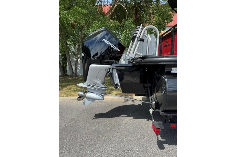 2026 Regency 230 DL boat with Mercury outboard motor, parked outdoors.