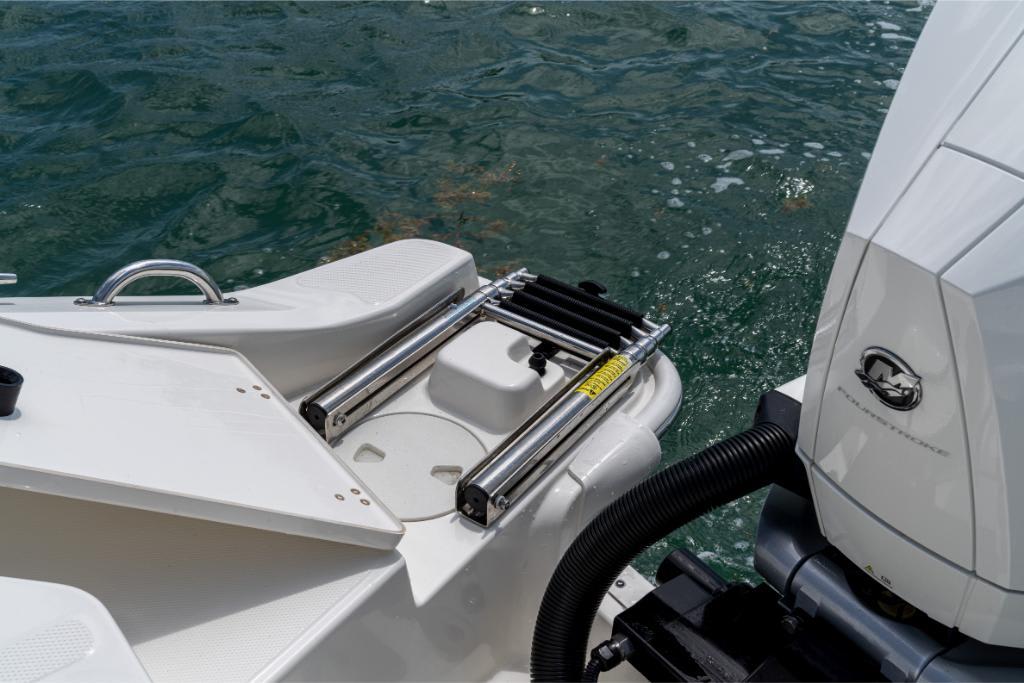 2024 Boston Whaler 280 Dauntless swim platform and ladder near outboard motor.