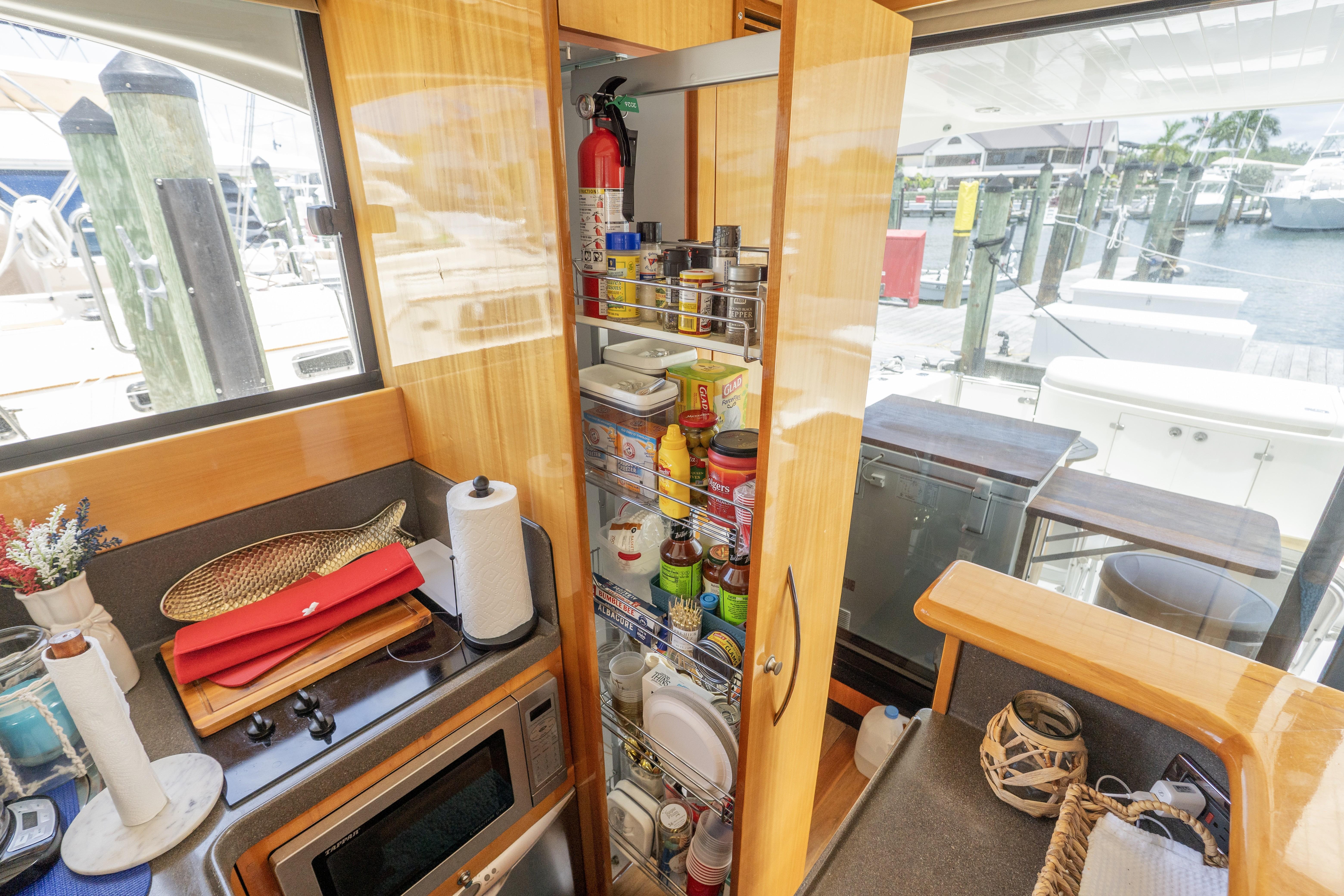 Compact kitchen area on a 2008 Maritimo 52 yacht with pantry and microwave.
