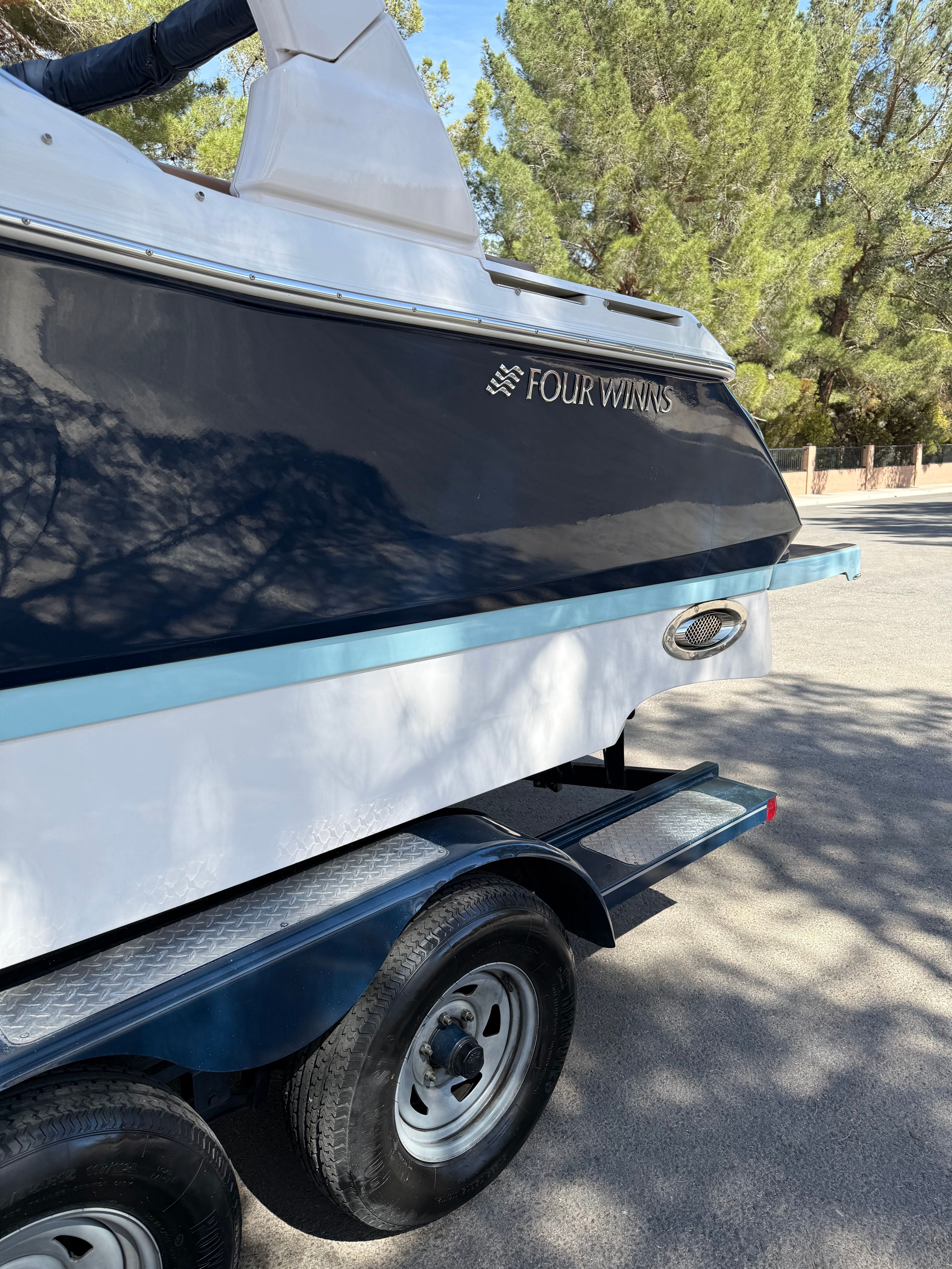 2019 Four Winns H260 boat on trailer outdoors.