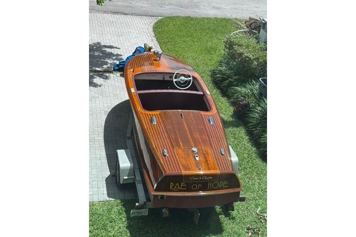 1952 Chris-Craft 18 Runabout boat on trailer, named "Rae of Hope," parked on grass.