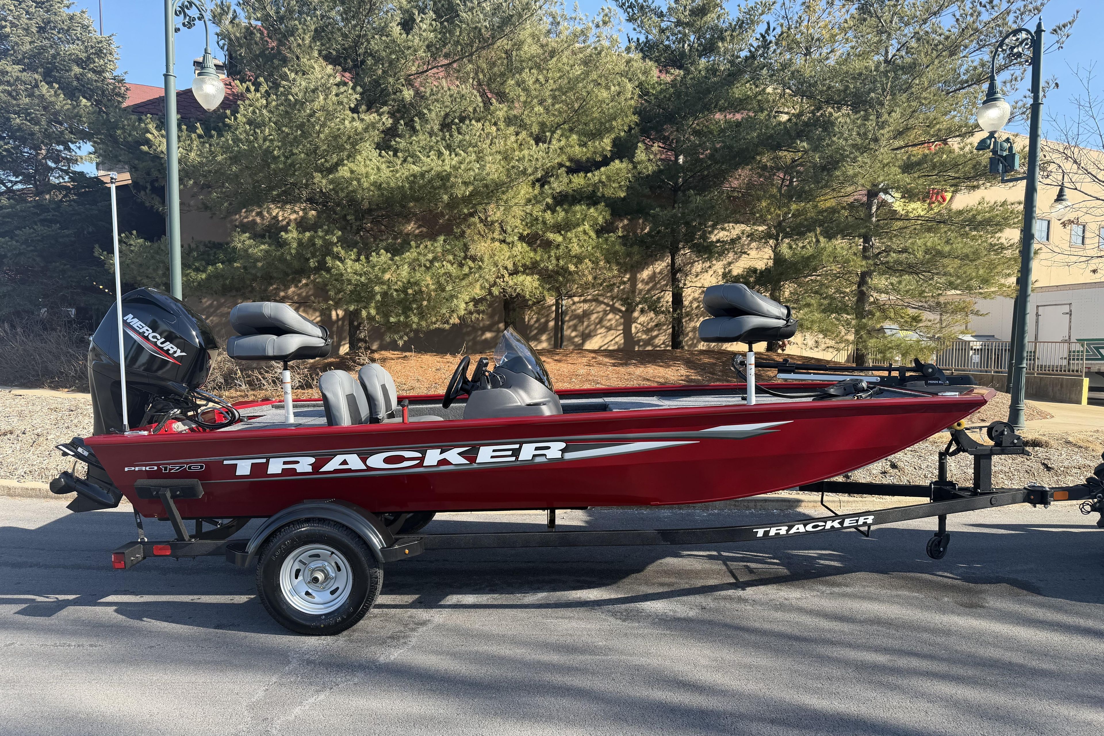 2026 Tracker Pro 170 boat on trailer, parked outdoors with trees in background.