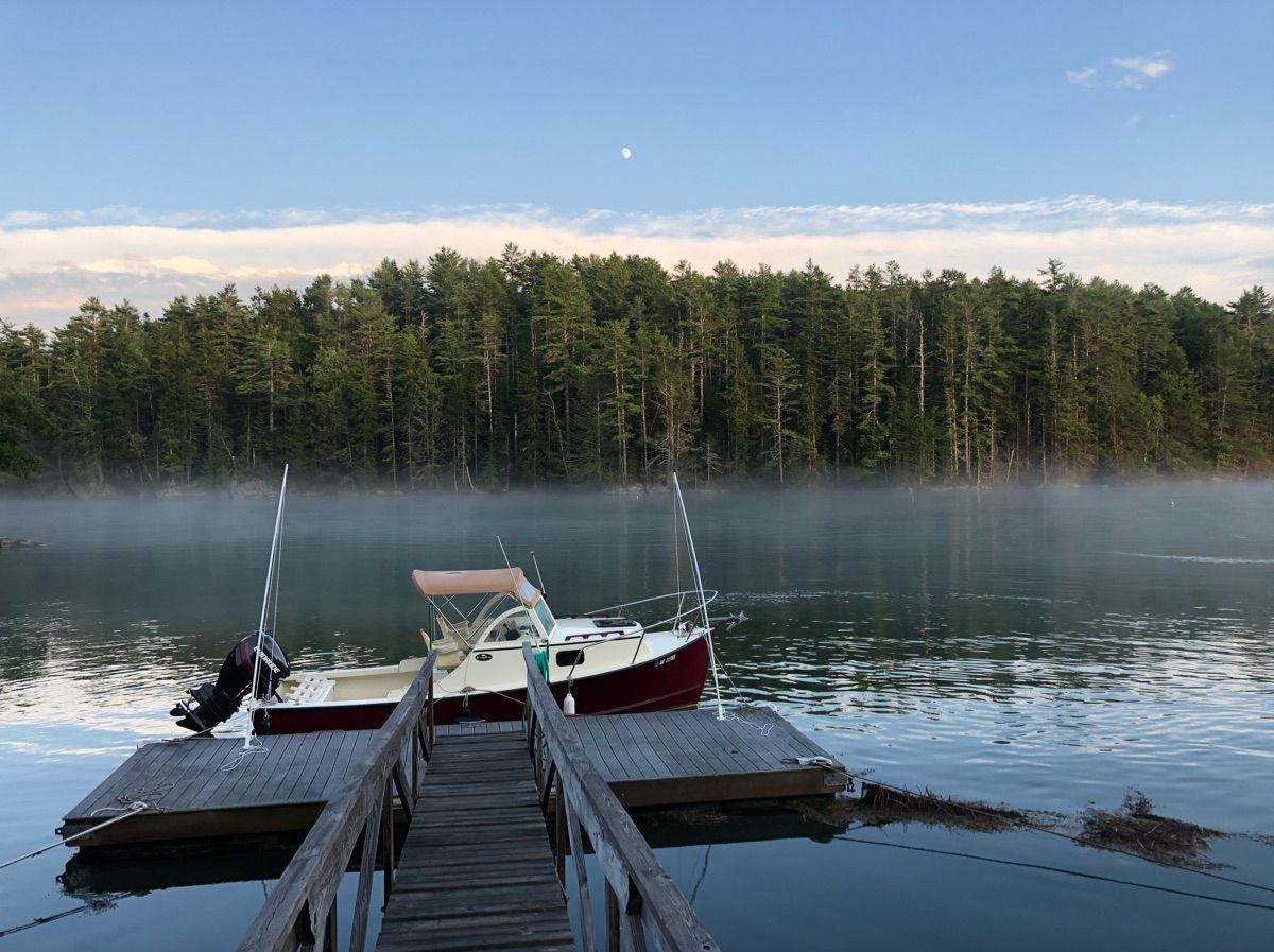 A 2018 Seaway Seafarer 21 boat docked at a tranquil pier, surrounded by misty water.