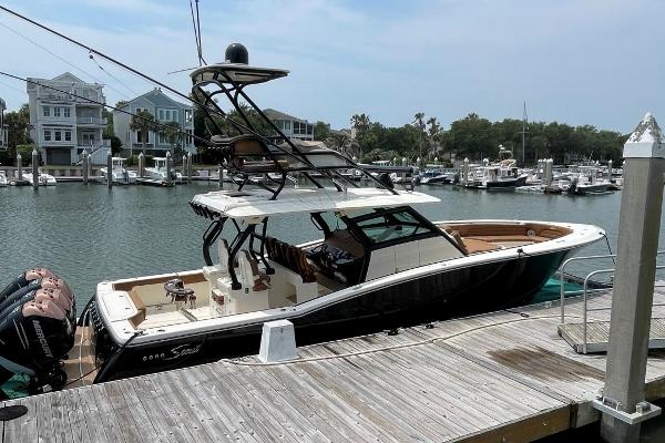 2020 Scout 420 LXF boat docked at marina with scenic waterfront view.