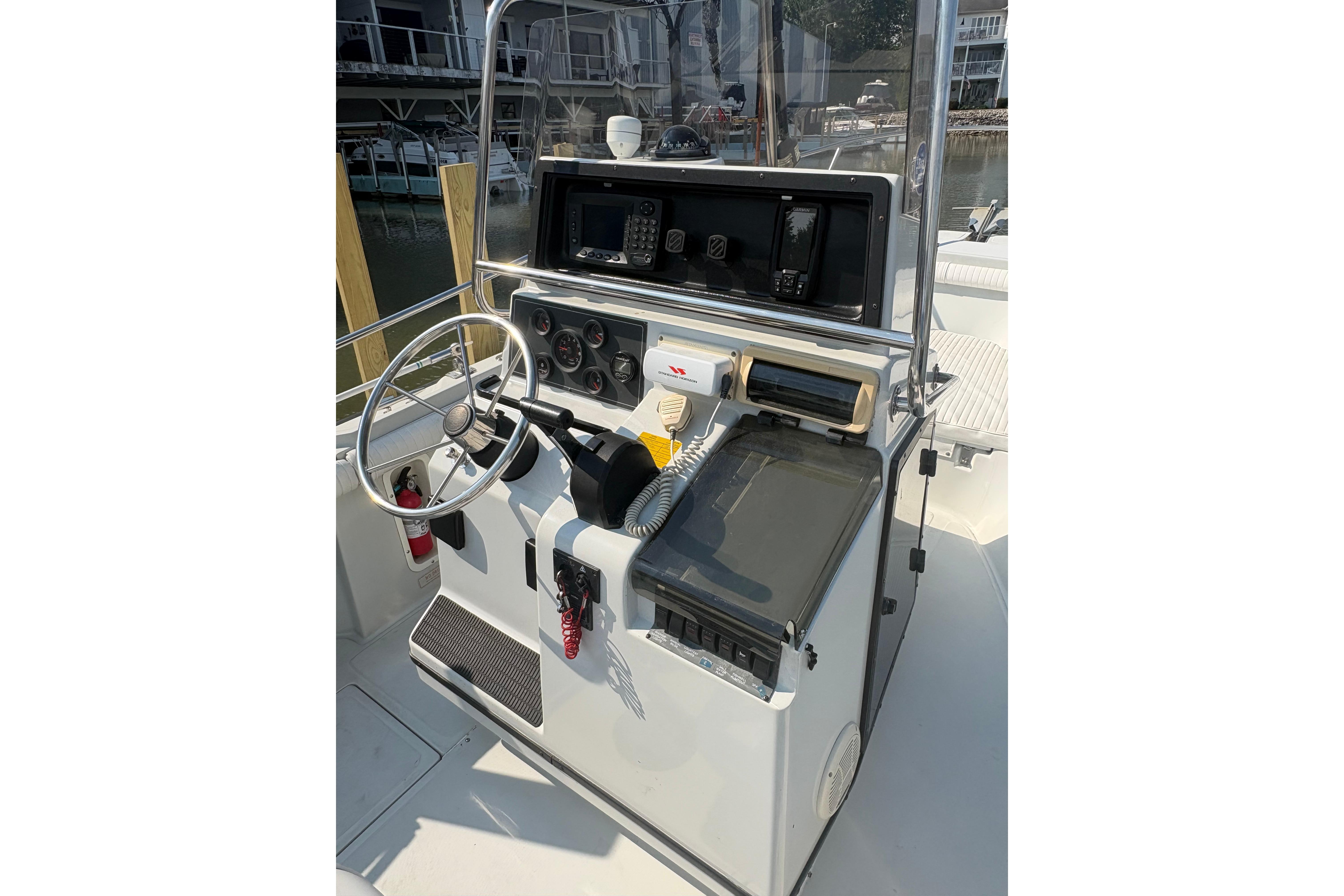 1993 Boston Whaler 21 Outrage boat console with steering wheel and navigation equipment.