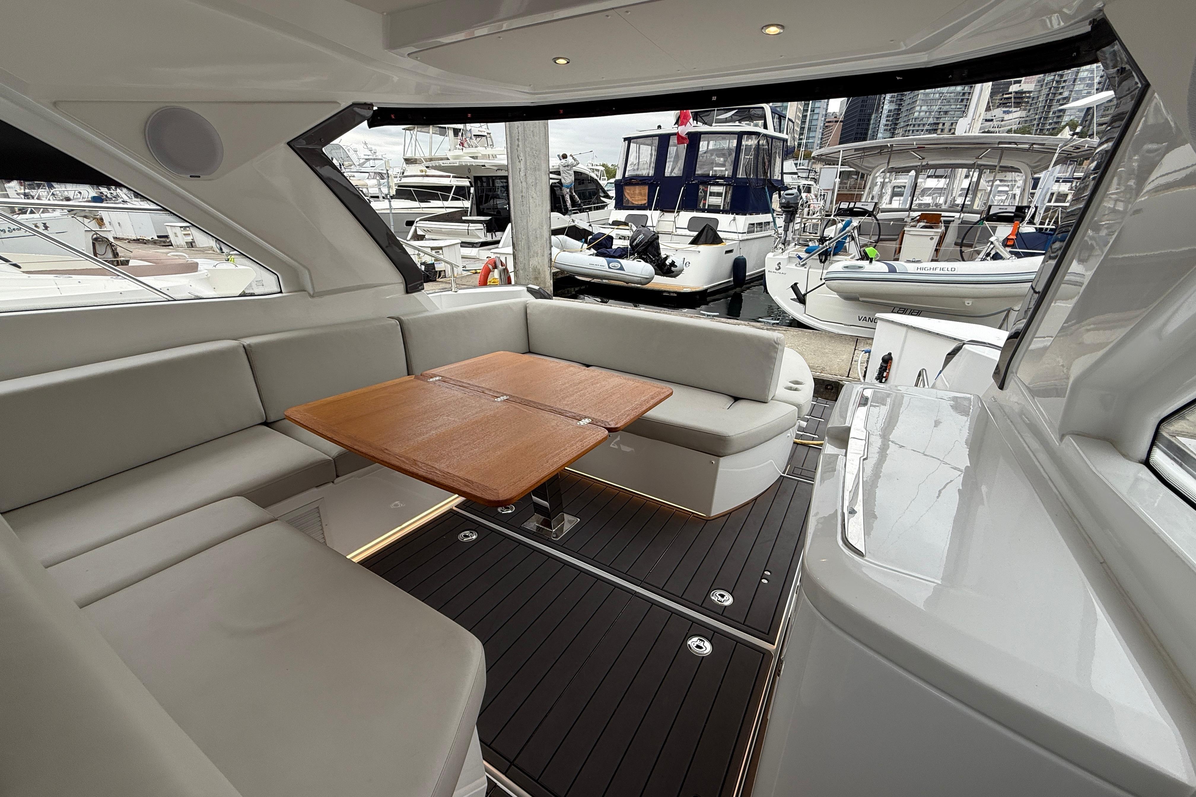 Luxurious 2022 Beneteau Gran Turismo 41 yacht interior with elegant seating and wooden table.