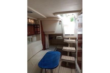 2005 Sea Ray 300 Sundancer interior with seating, table, and steps.