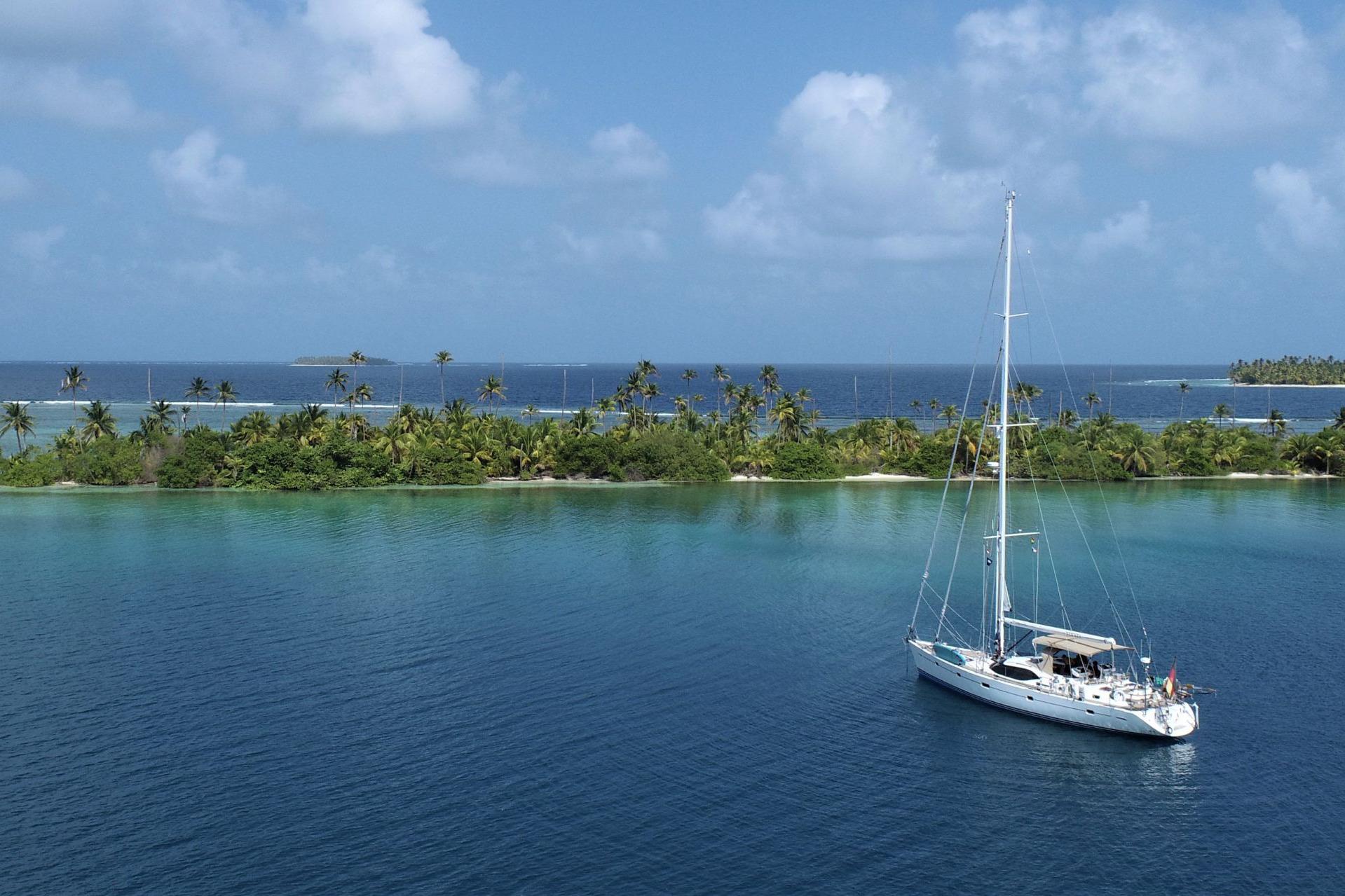 Sailing yacht Oyster 575 (2011) anchored near tropical island with palm trees and clear blue water.