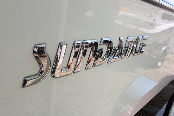 Chrome "Sundance" logo on 2023 Sundance DX20 boat exterior.