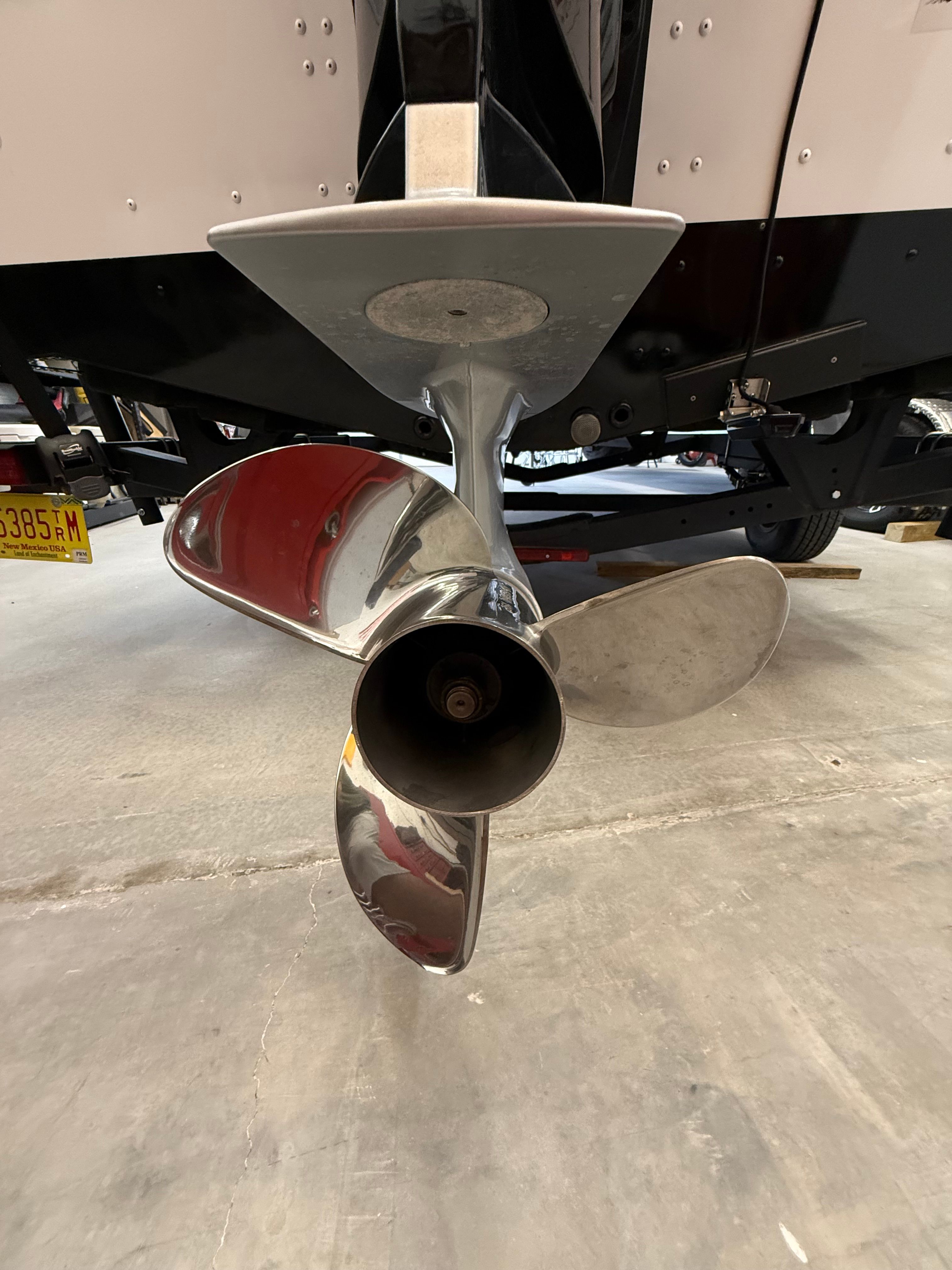 Close-up of a shiny propeller on a boat, situated in a garage.