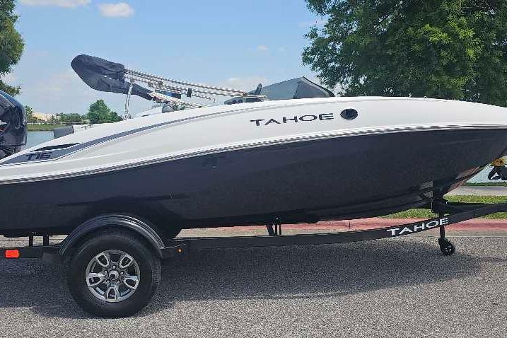 2026 Tahoe T16 boat on trailer, parked outdoors under a clear blue sky.