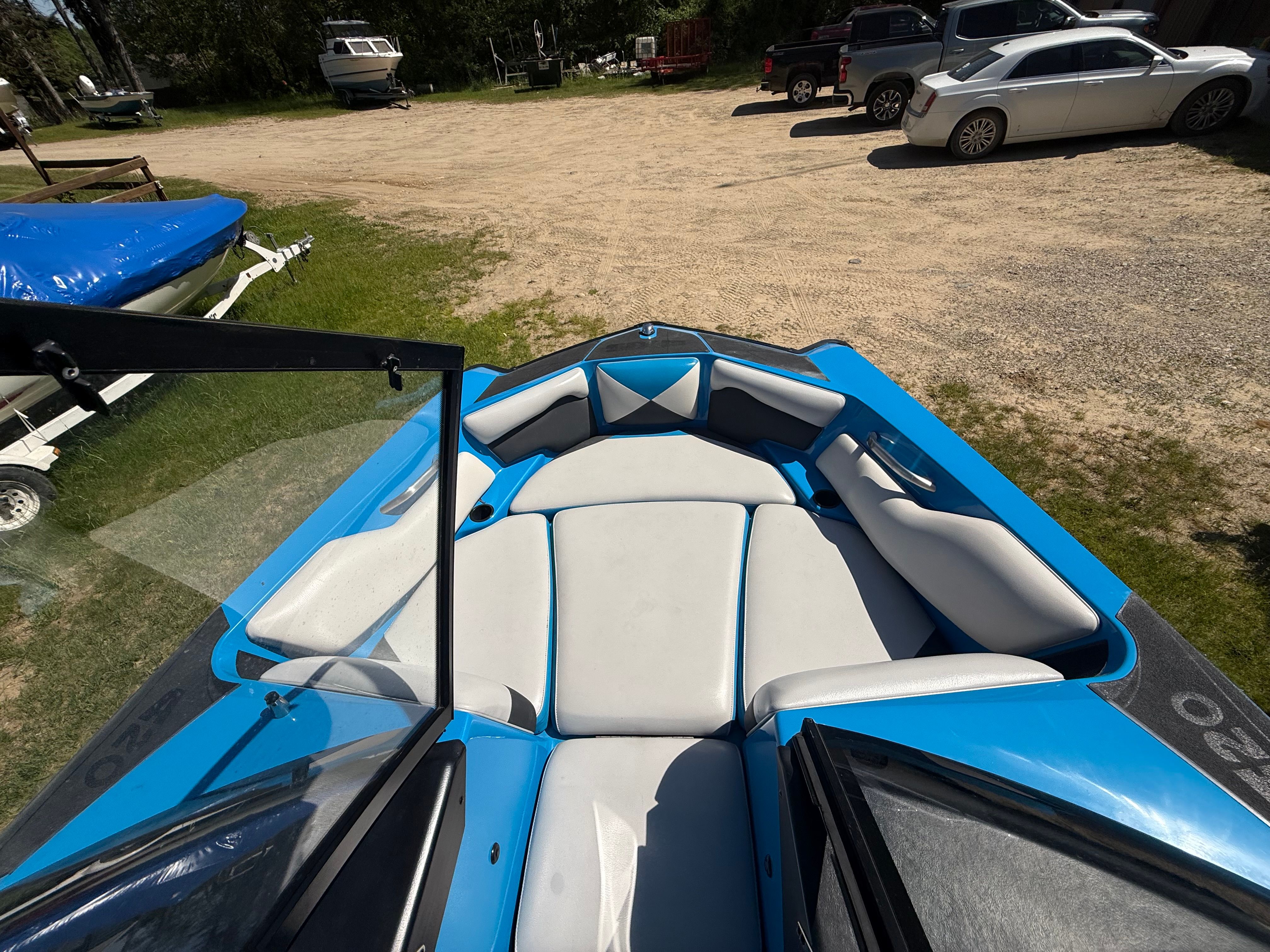 Interior of a blue 2015 Malibu Axis A20 boat on a parking lot.