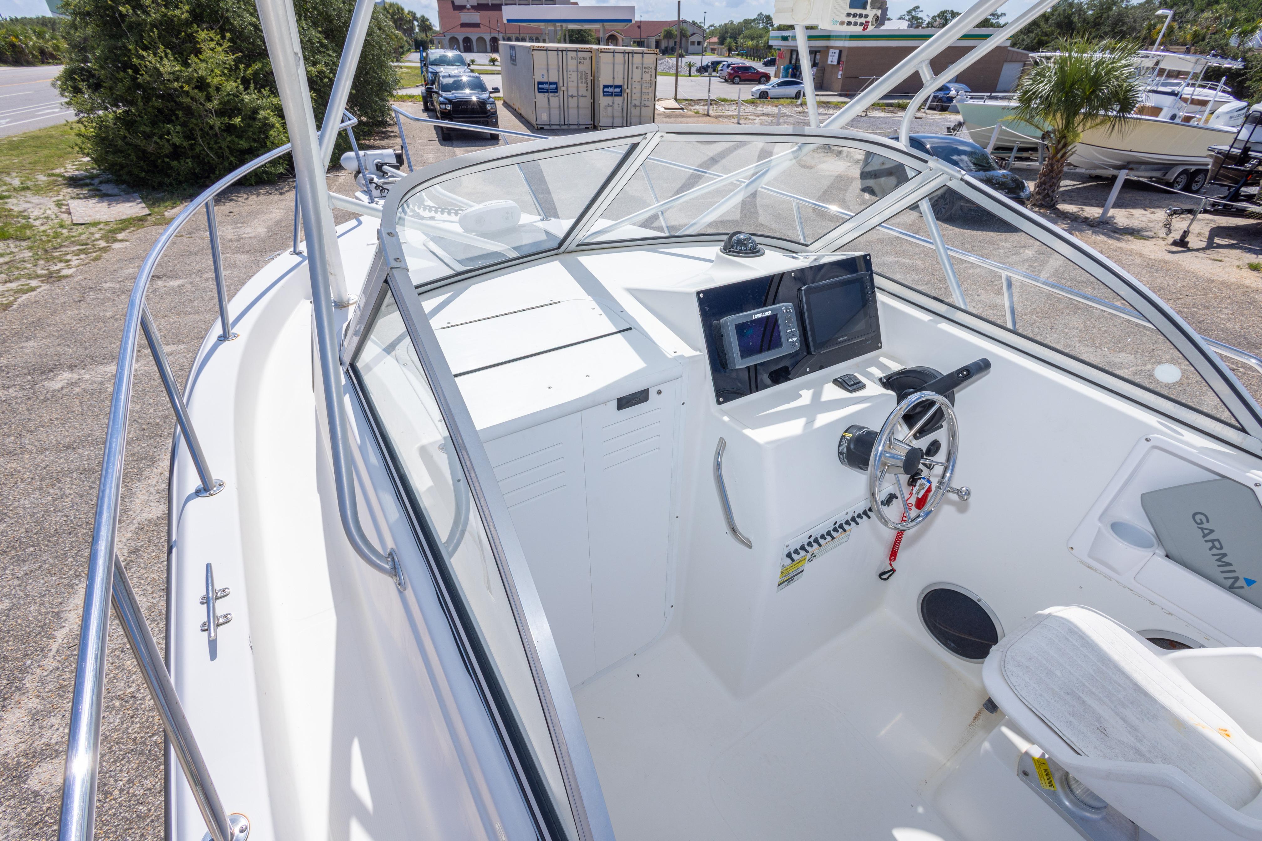 2007 Sea Boss 235 Walkaround boat cockpit with steering wheel and navigation equipment.