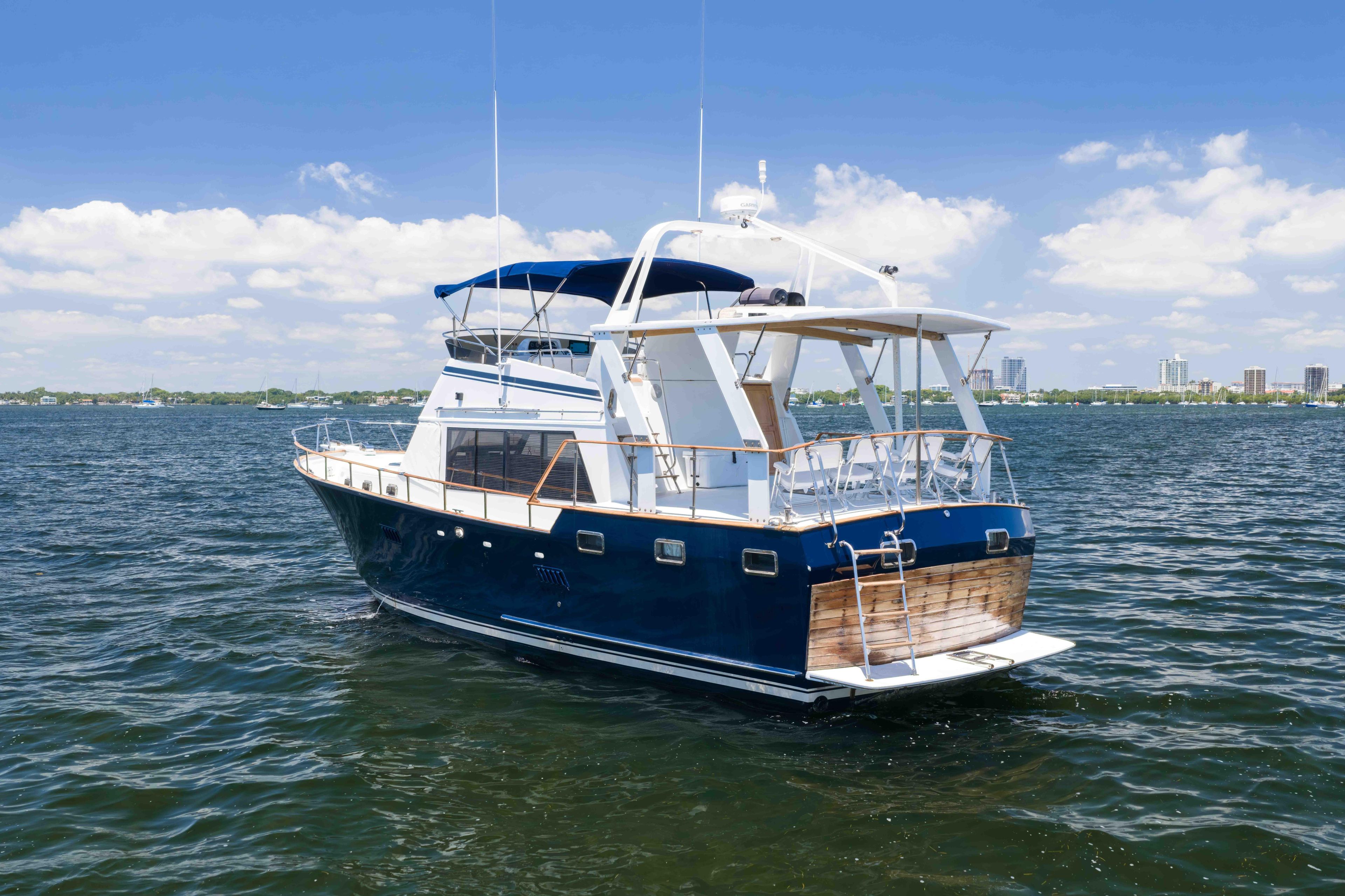 1983 Sea Ranger 45 Sundeck yacht on calm water under a clear blue sky.