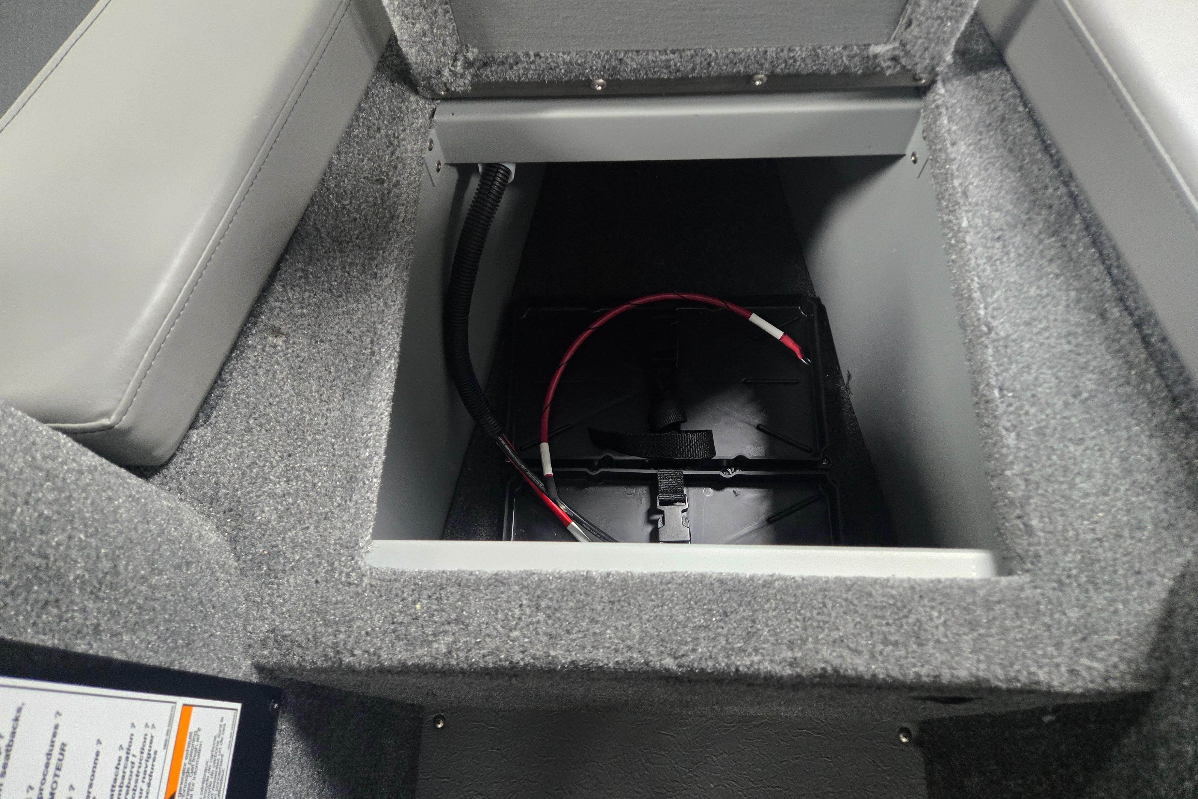 Battery compartment of 2026 Princecraft Sport 175 MAX boat, featuring gray interior and wiring.