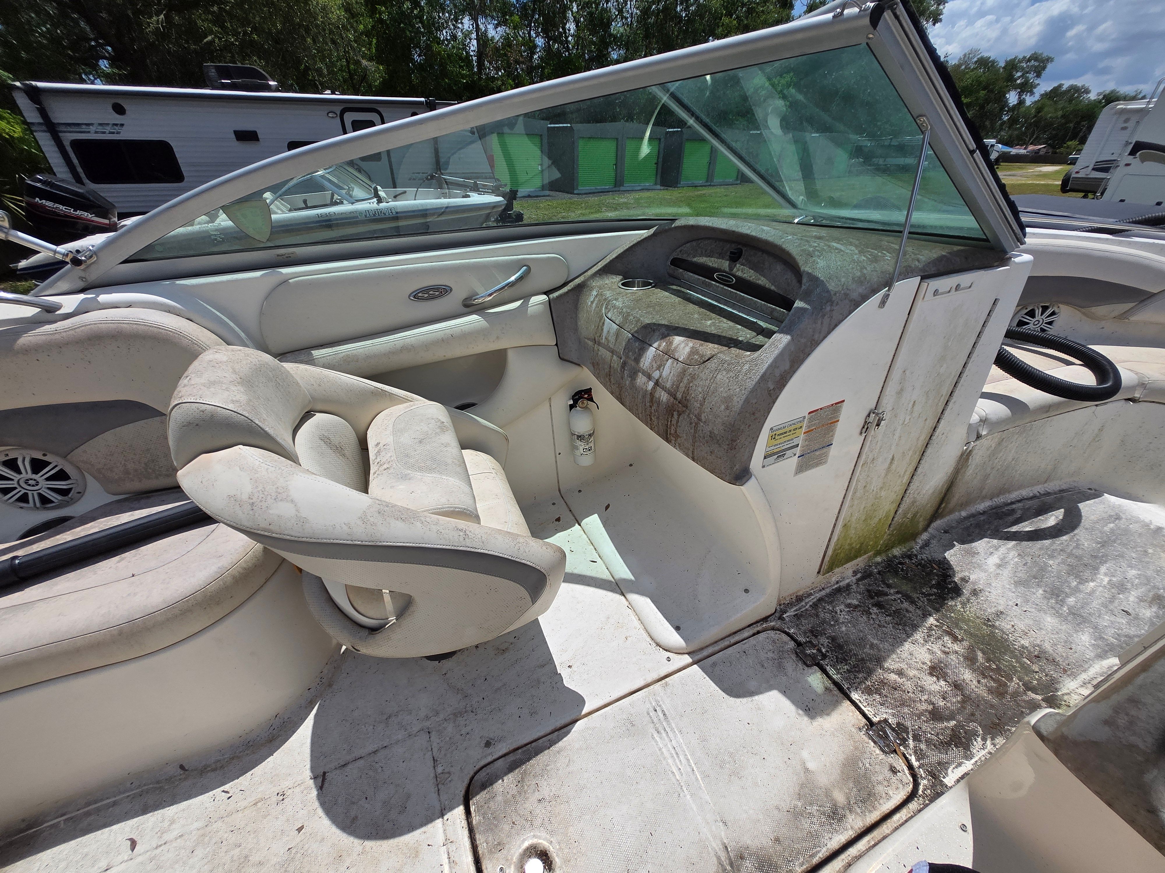 The image shows the cockpit of a 2006 Chaparral 220 SSi boat with worn seats.