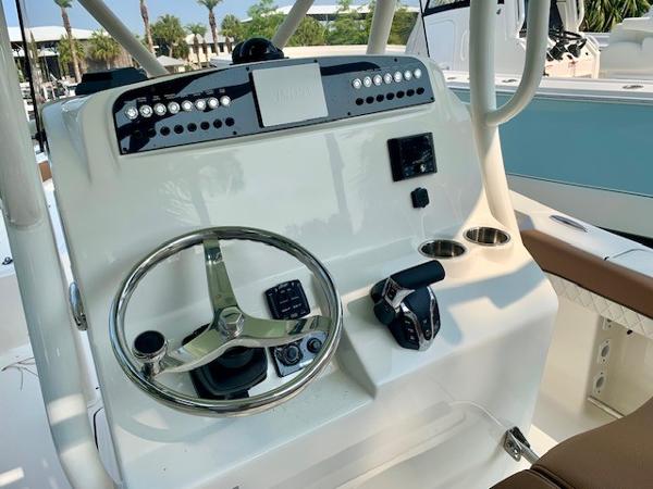 2025 Pioneer 222 Islander boat console with steering wheel, controls, and cup holders.
