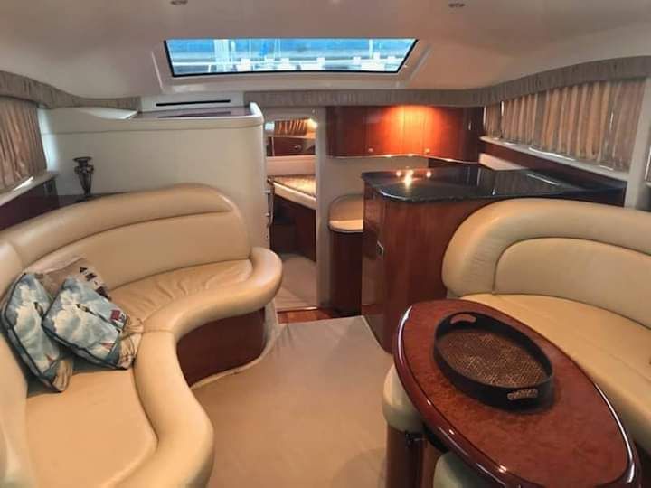 Interior of a 2004 Sea Ray Sedan Bridge with elegant leather sofas and wooden furnishings.