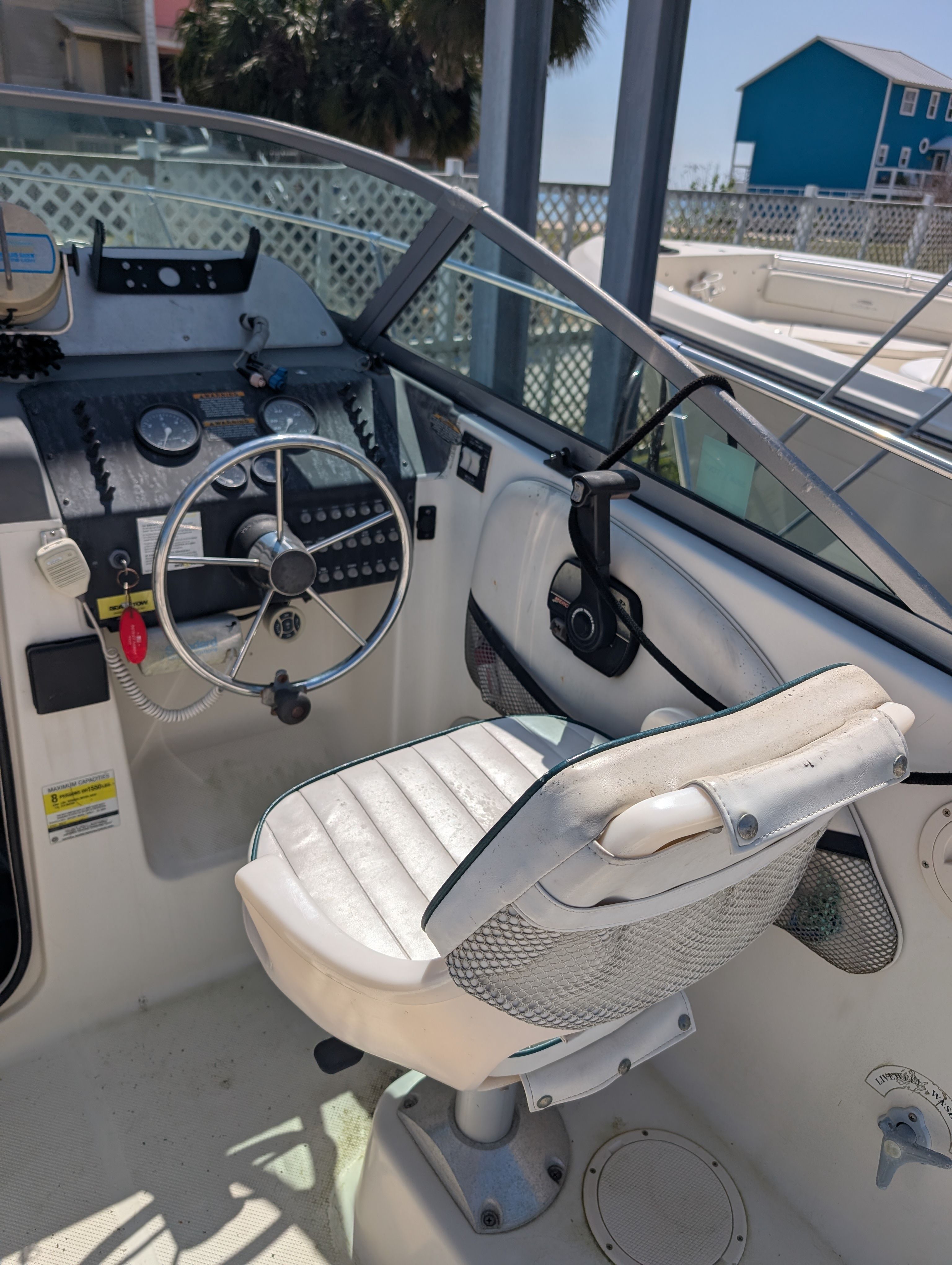 The image shows the cockpit of a 2001 Trophy Bayliner boat with a white captain's chair and steering.