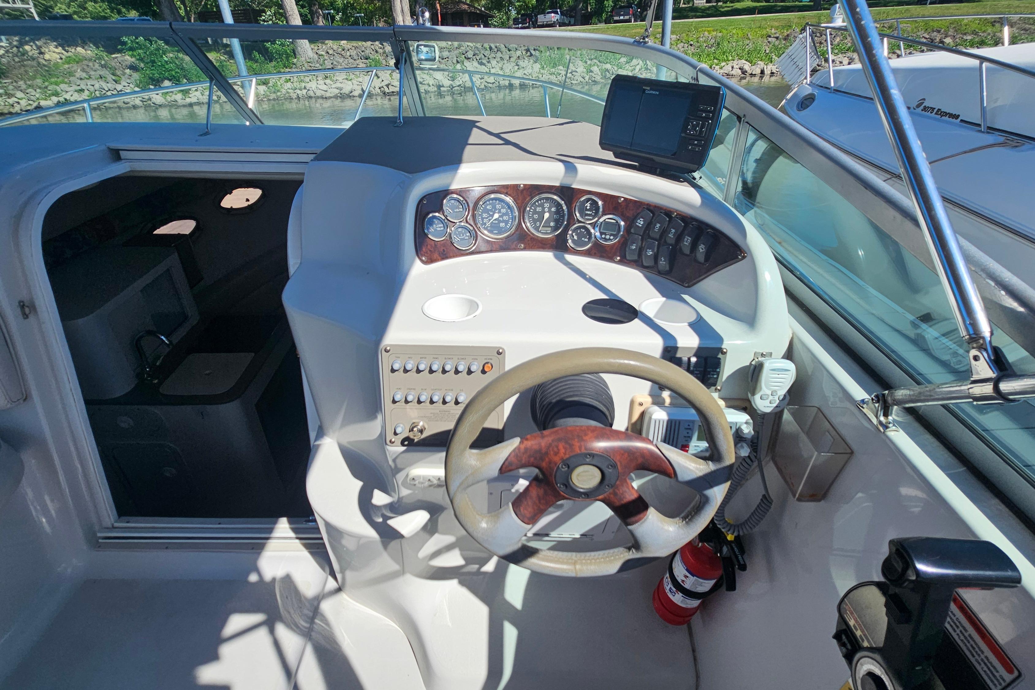 Cockpit view of 2000 Crownline 242 CR boat with steering wheel and control panel.