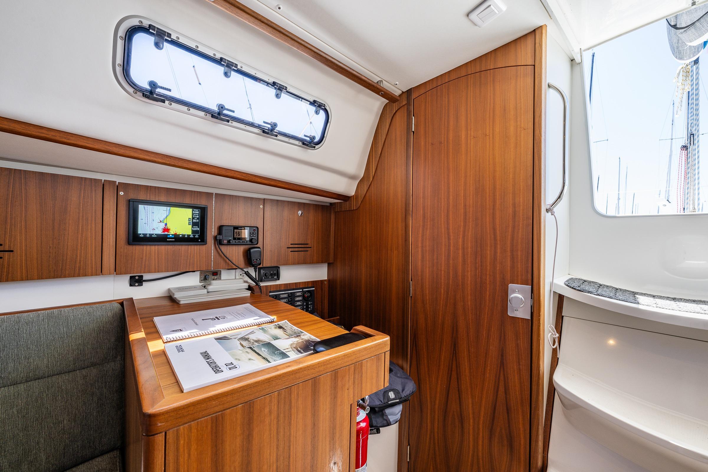 Interior of 2018 J Boats J/97E sailboat with navigation equipment and wooden cabinetry.