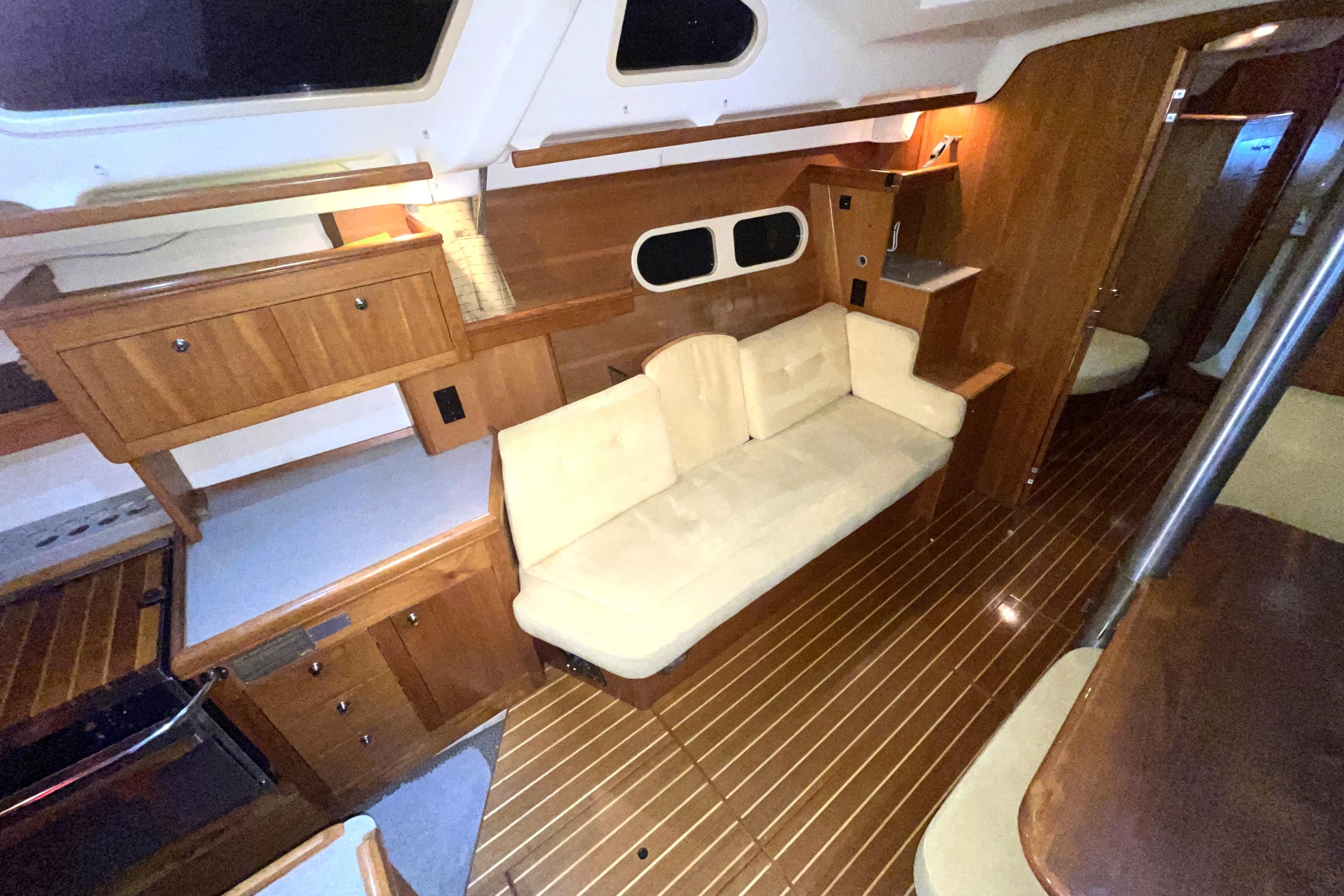 Interior of 2002 Hunter Passage 450 yacht with wooden cabinetry and beige seating.