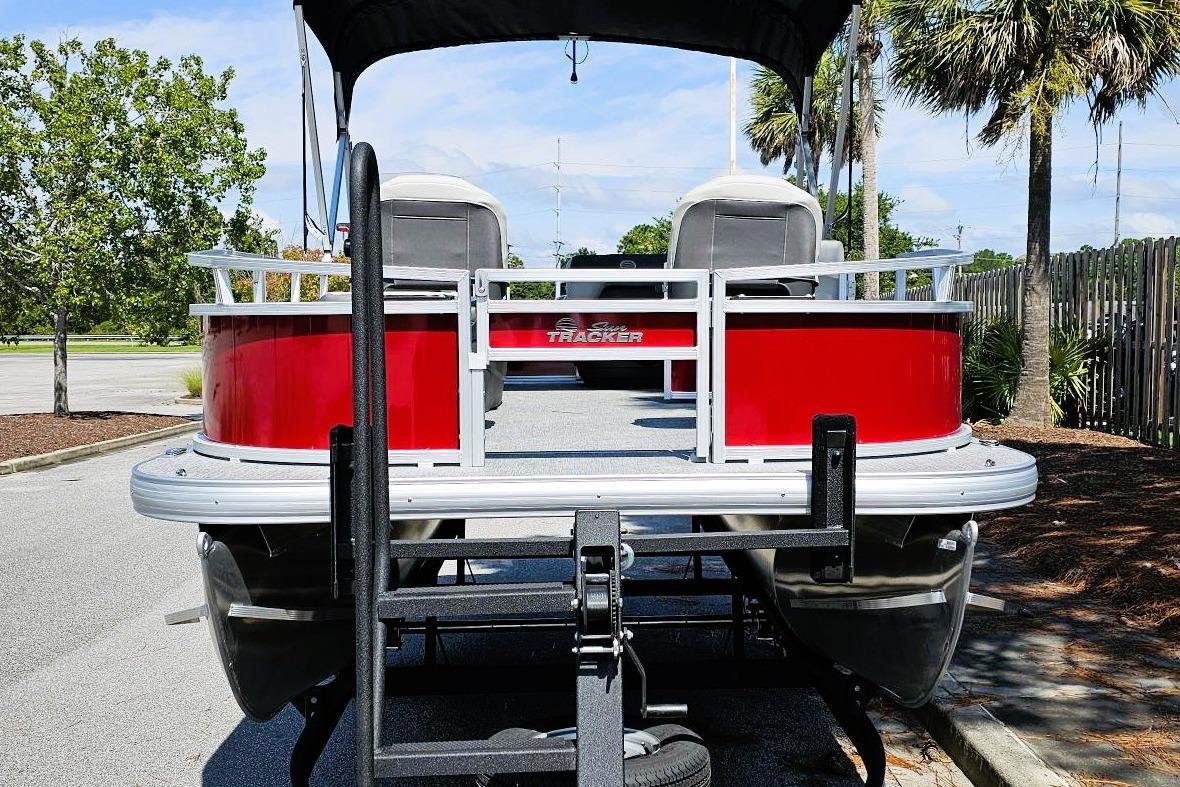 2026 Sun Tracker Bass Buggy 16 XL Select pontoon boat, red exterior, parked outdoors.