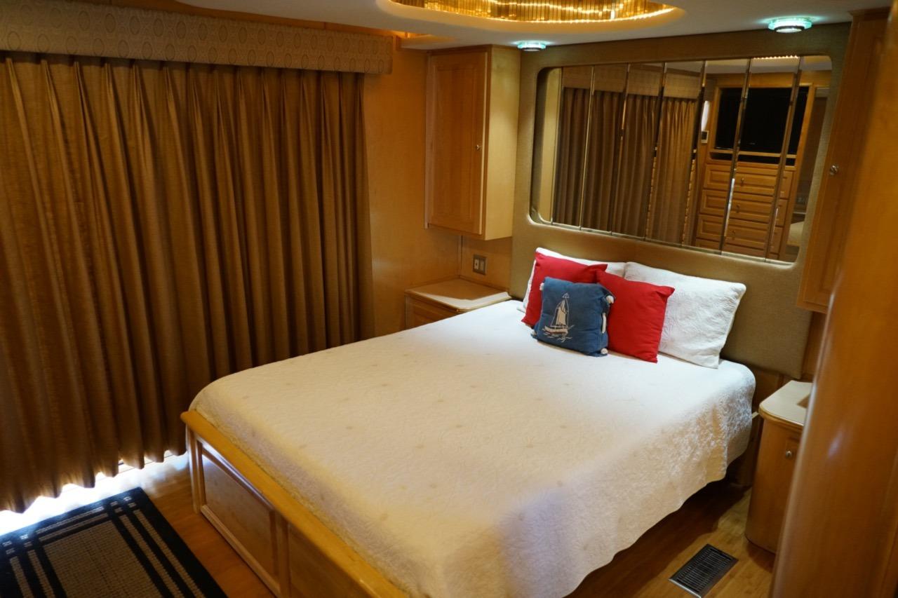 Luxurious bedroom interior in 2000 Stardust Cruisers houseboat, featuring cozy bed and elegant decor.