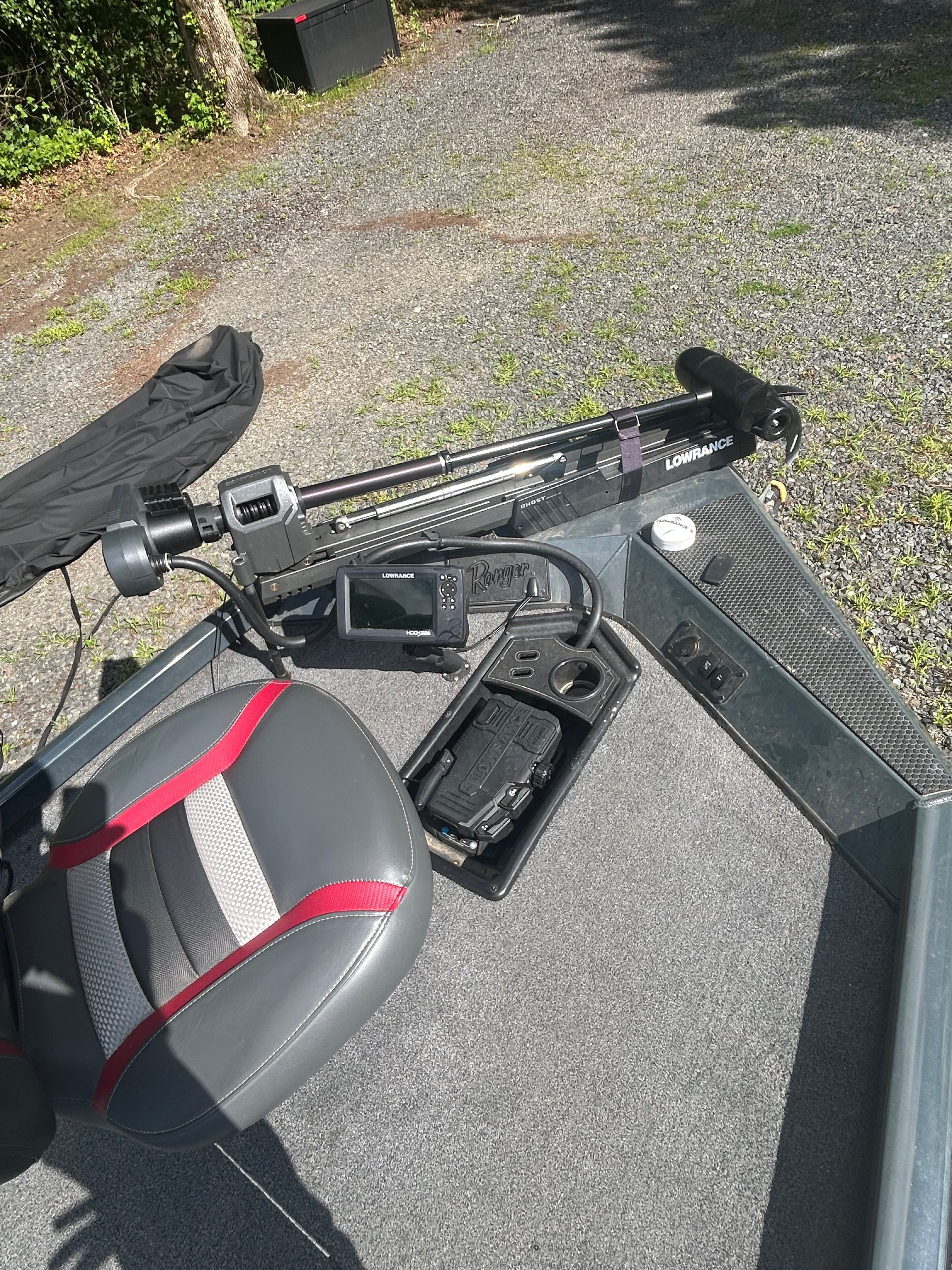 A boat with a gray and red seat, a Lowrance device, and a gray floor.
