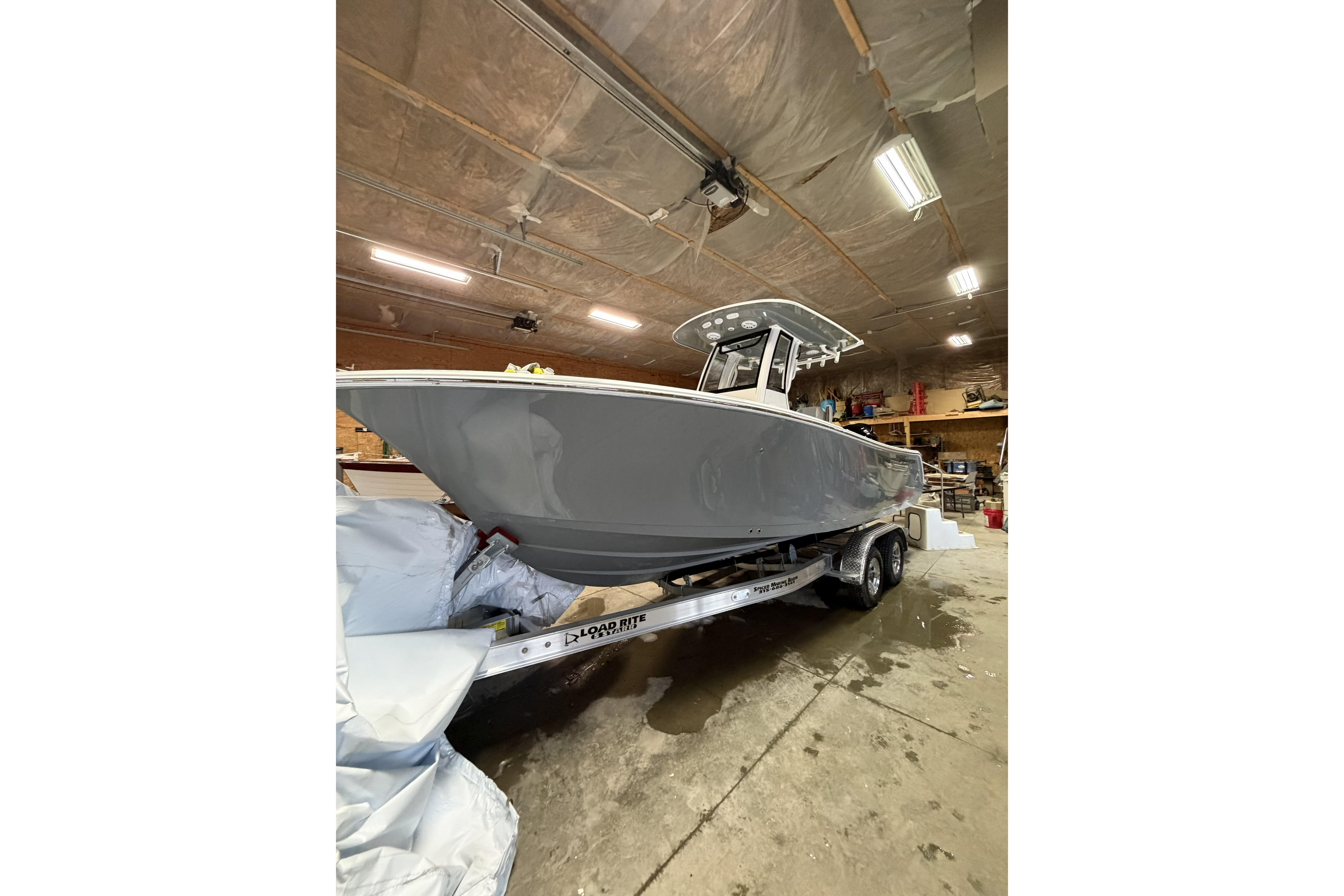 2026 Sportsman Open 232 Center Console boat on trailer in a garage.